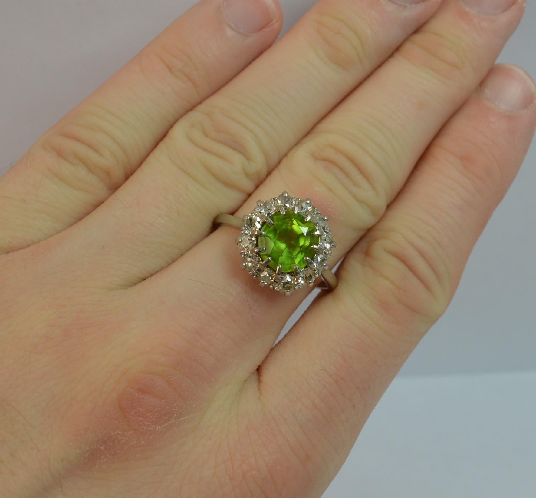 A superb true antique cluster ring.
Ring Size; 10 1/2 UK, 9 3/4 US
Solid platinum piece throughout.
Set with a large oval peridot to the centre, 8.6mm x 9.2mm approx. Surrounding are twelve natural old cut diamonds to total approx 1.00 carats.

14mm