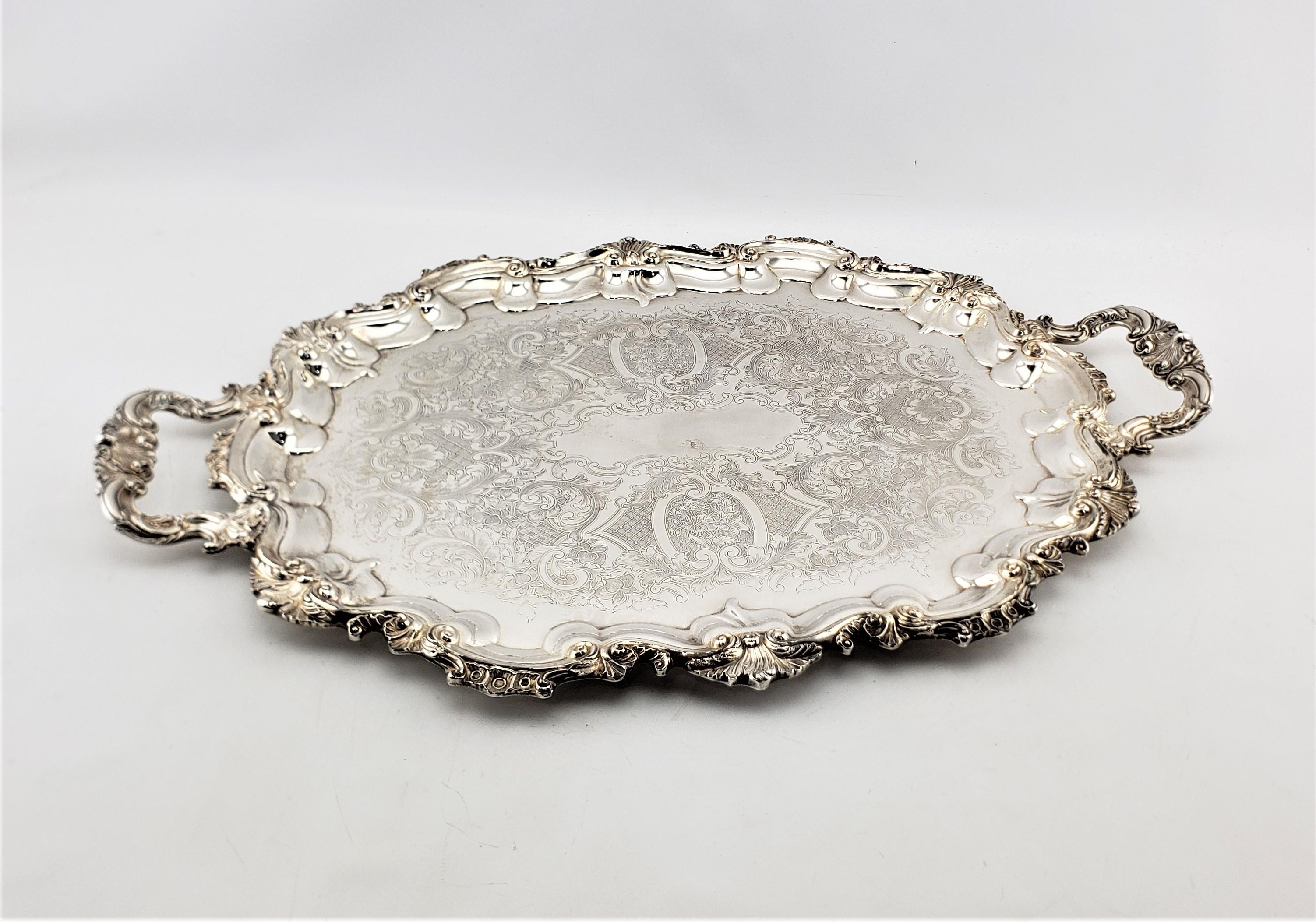 This large antique silver plated serving tray was made by the well known Primrose Plate company of Canada and dates to approximately 1920 and done in a Victorian style. The tray is ornately decorated along the sides with stylized shell and leaves