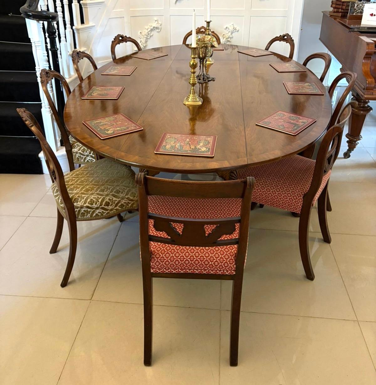Large antique quality figured walnut 10 Seater wake dining table having a large quality figured walnut crossbanded top with 2 oval drop leaves standing on 8 shaped carved cabriole legs with pad feet and 4 legs are swing out gatelegs.

A magnificent