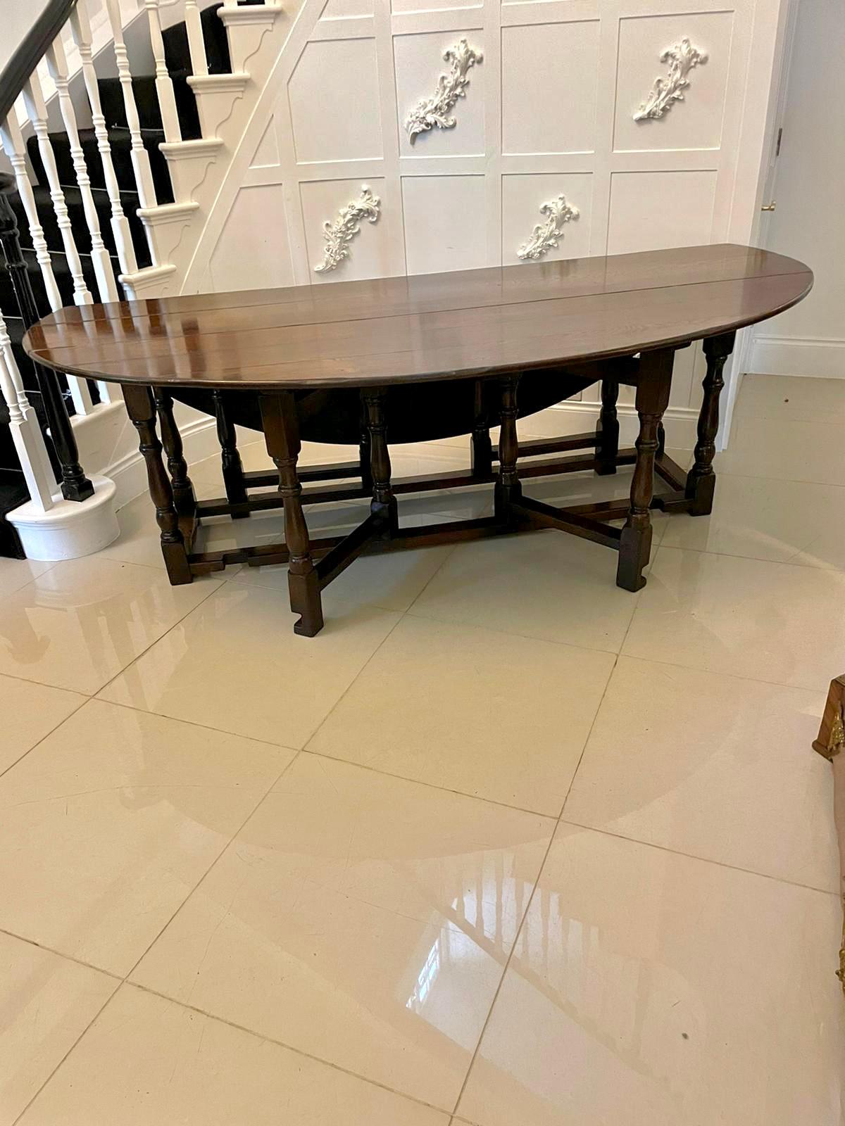 Large antique quality oak gateleg dining table having a quality large oak top with two oval drop leaves supported by turned tapering columns and 4 four gatelegs with turned tapering columns united by oak stretchers and raised on block feet 

A