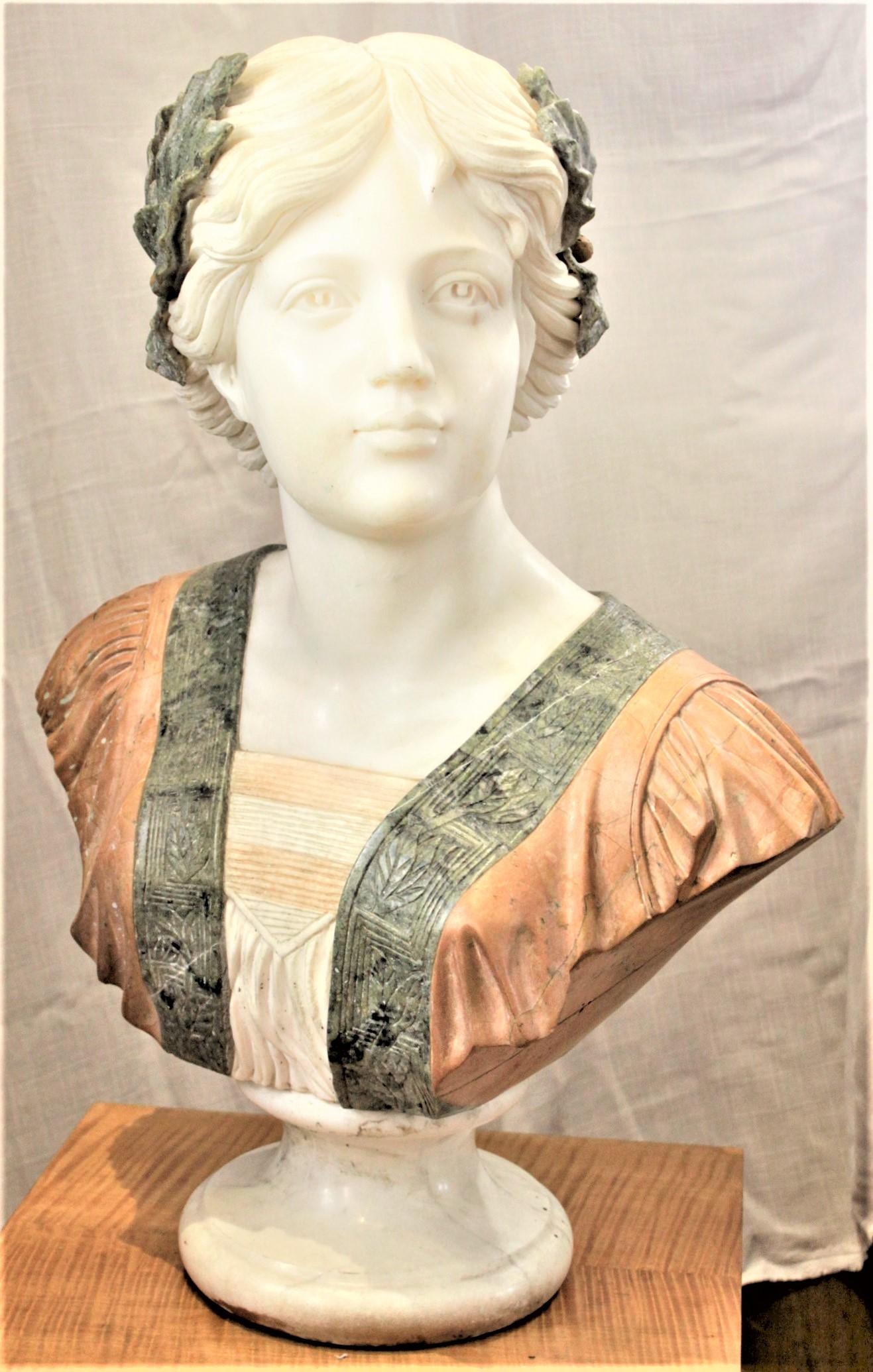 This very large and well executed antique mixed marble and hardstone sculpture is unsigned, but presumed to have been done in Italy in circa 1880 in a Renaissance style. The bust depicts a woman in a robe and dress with leaves adorning her hair with