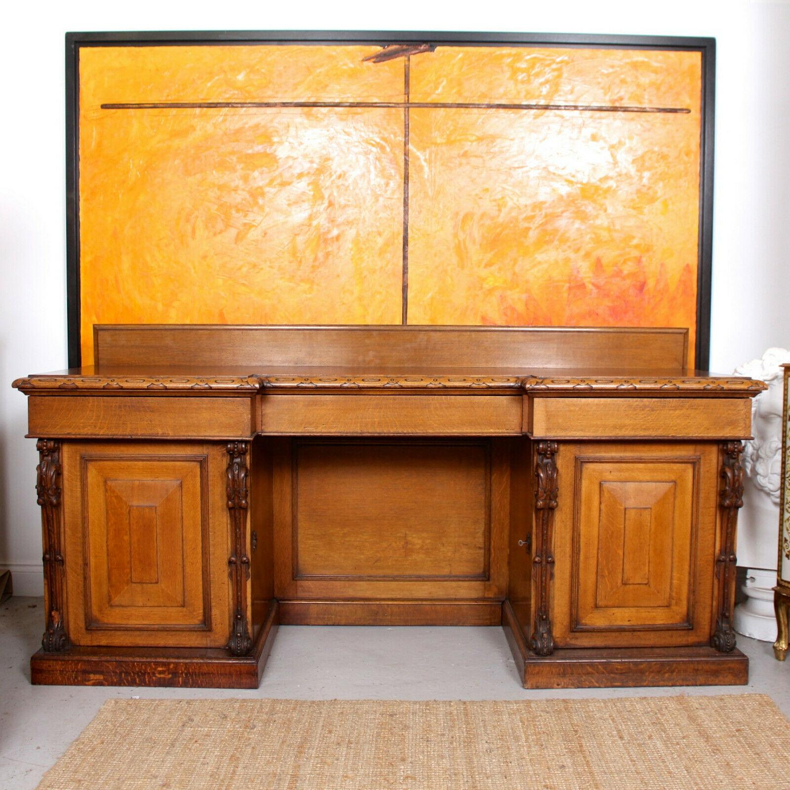 An outstanding 19th century reverse breakfront kneehole oak sideboard.

The oak boasting a rich honey patina and well figured wild golden flecked grain.

A backrail above the reverse breakfront form top with intricately carved edges fitted three