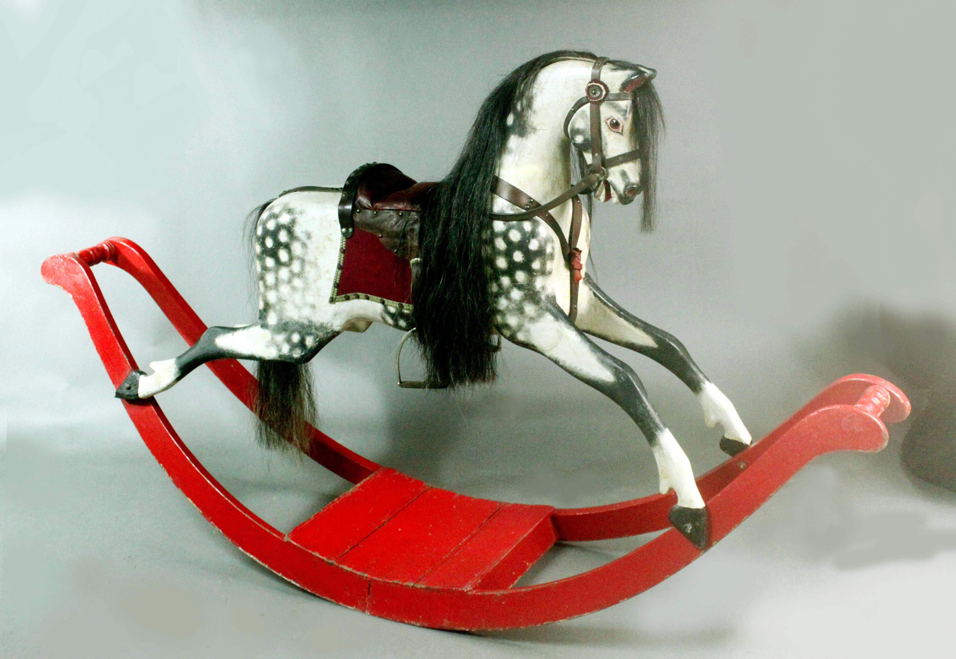Large Antique Rocking Horse on Curved Wooden Rockers
Large carved wooden rocking horse on curved rockers attributed to Lines Brothers; the original paint has been retained with a small amount of sensitive restoration; the mane and tail have been