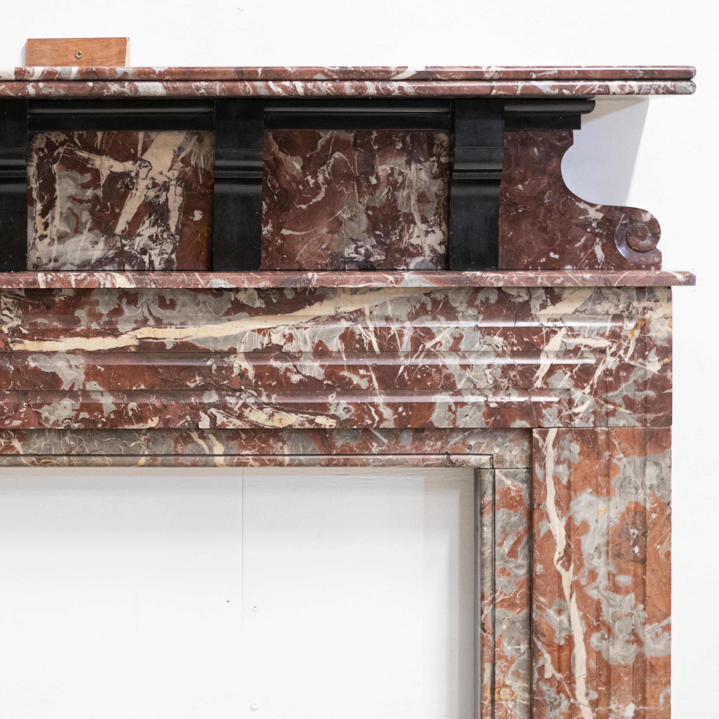 Crafted from striking Rogue Royal Red Marble, this antique chimneypiece has a double mantel and delivers generous height.

The Rouge Royal marble provides warmth and complements the black slate details including 4 corbels that support the upper