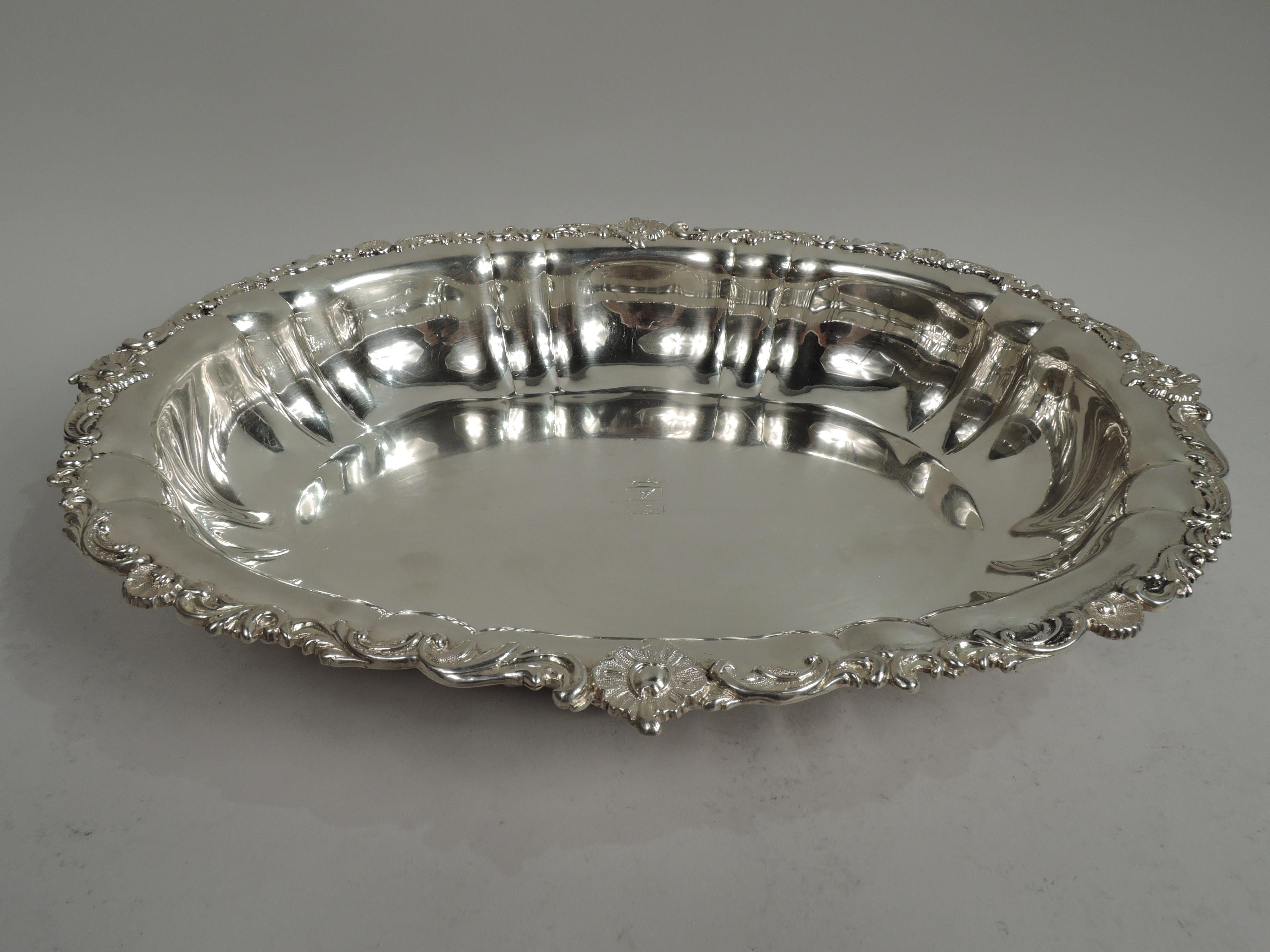 Large Russian Classical 875 silver bowl, ca 1843. Oval well with engraved armorial and curved and fluted sides with applied scroll and shell armorials (vacant). Rim has applied leaves, scrolls, and scallop shells. Fully marked including Adolf Sper
