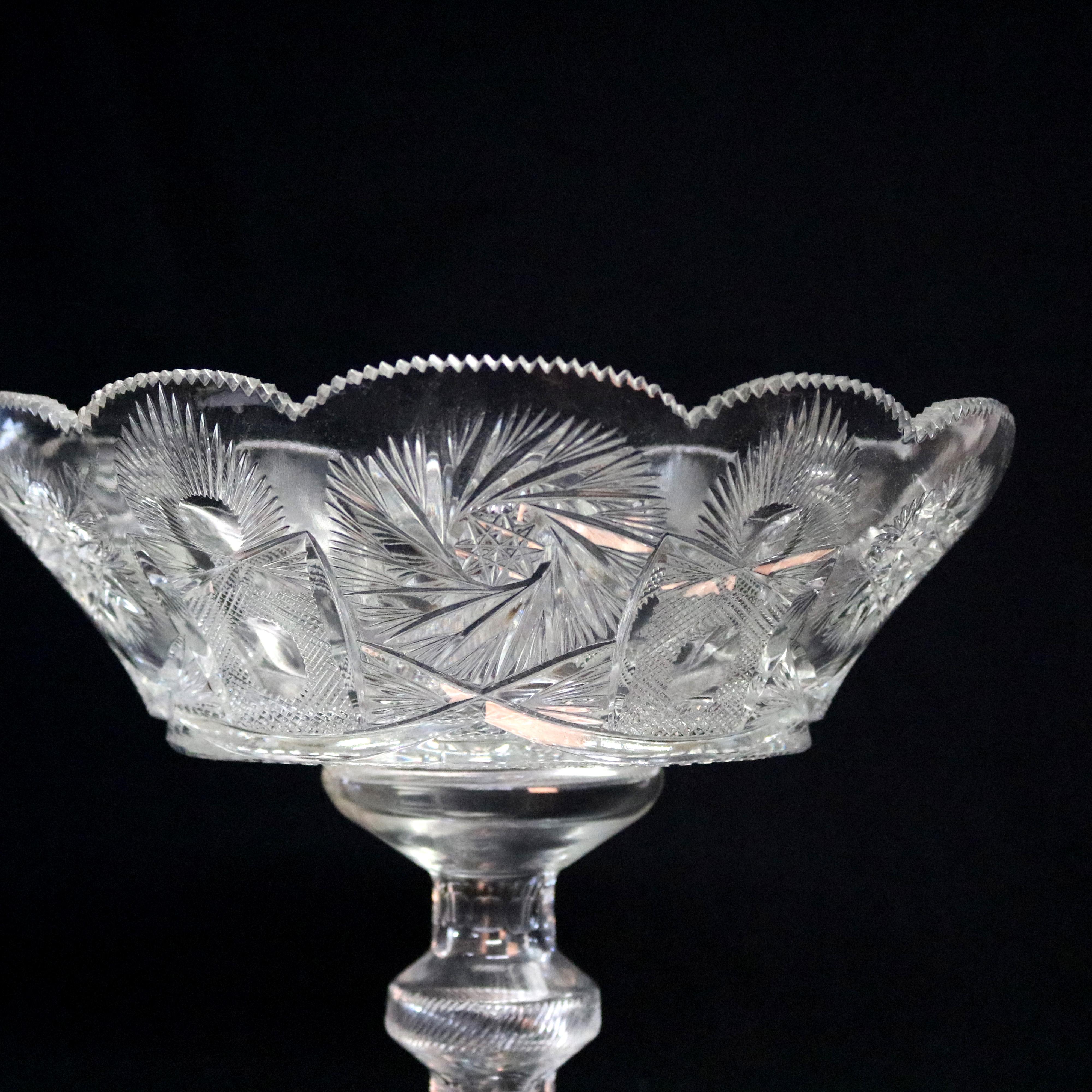 An antique Russian cut crystal center compote offers flare and faceted bowl with scalloped rim and facets having alternating cut star and pinwheel pattern, raised on pedestal seated on stepped base, Artist-signed as photographed, circa