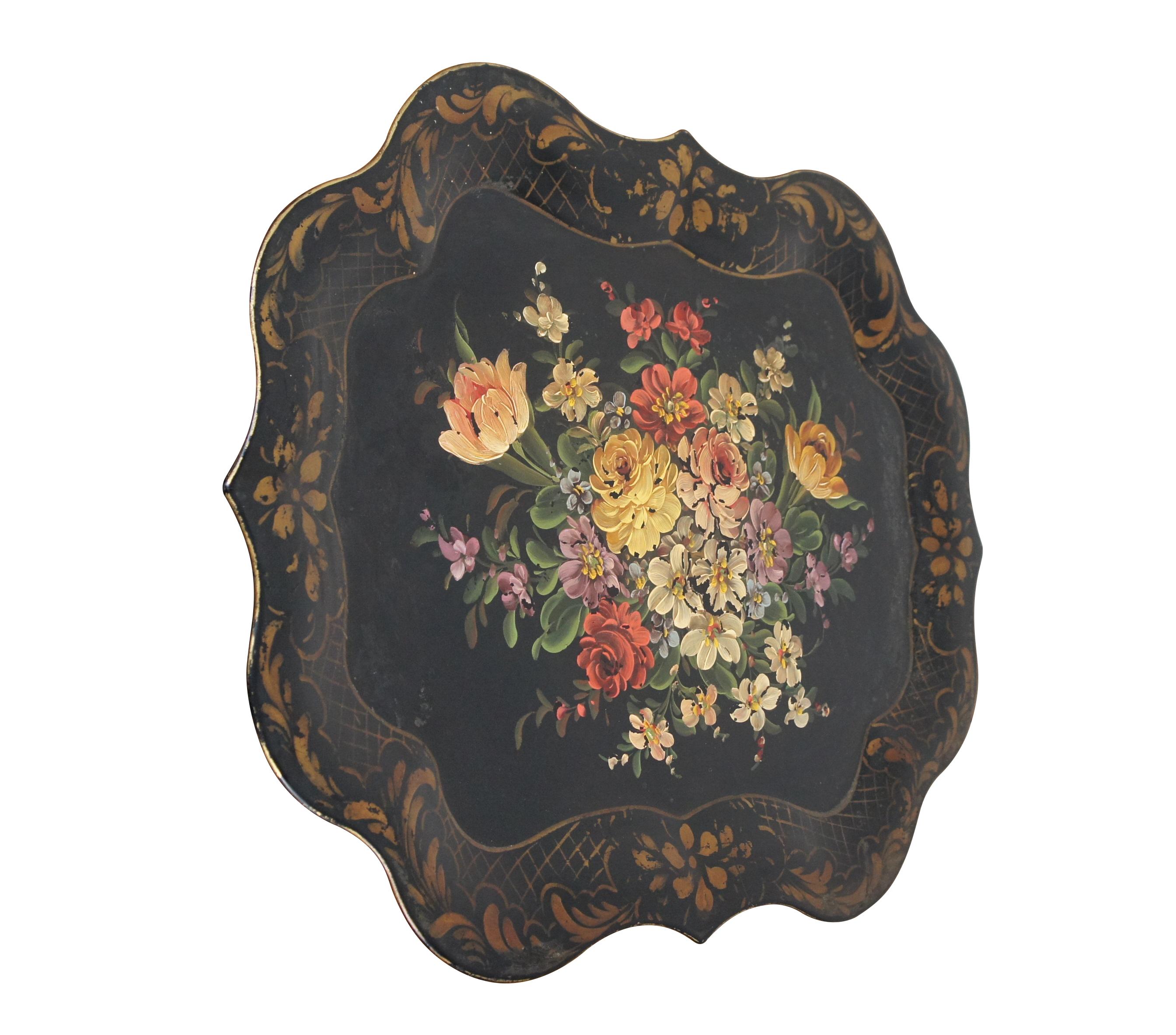 Early 20th century black metal tole serving tray with scalloped Chippendale style edge, hand painted with a pattern in gold around the border and a bouquet of flowers at the center.

Dimensions:
25