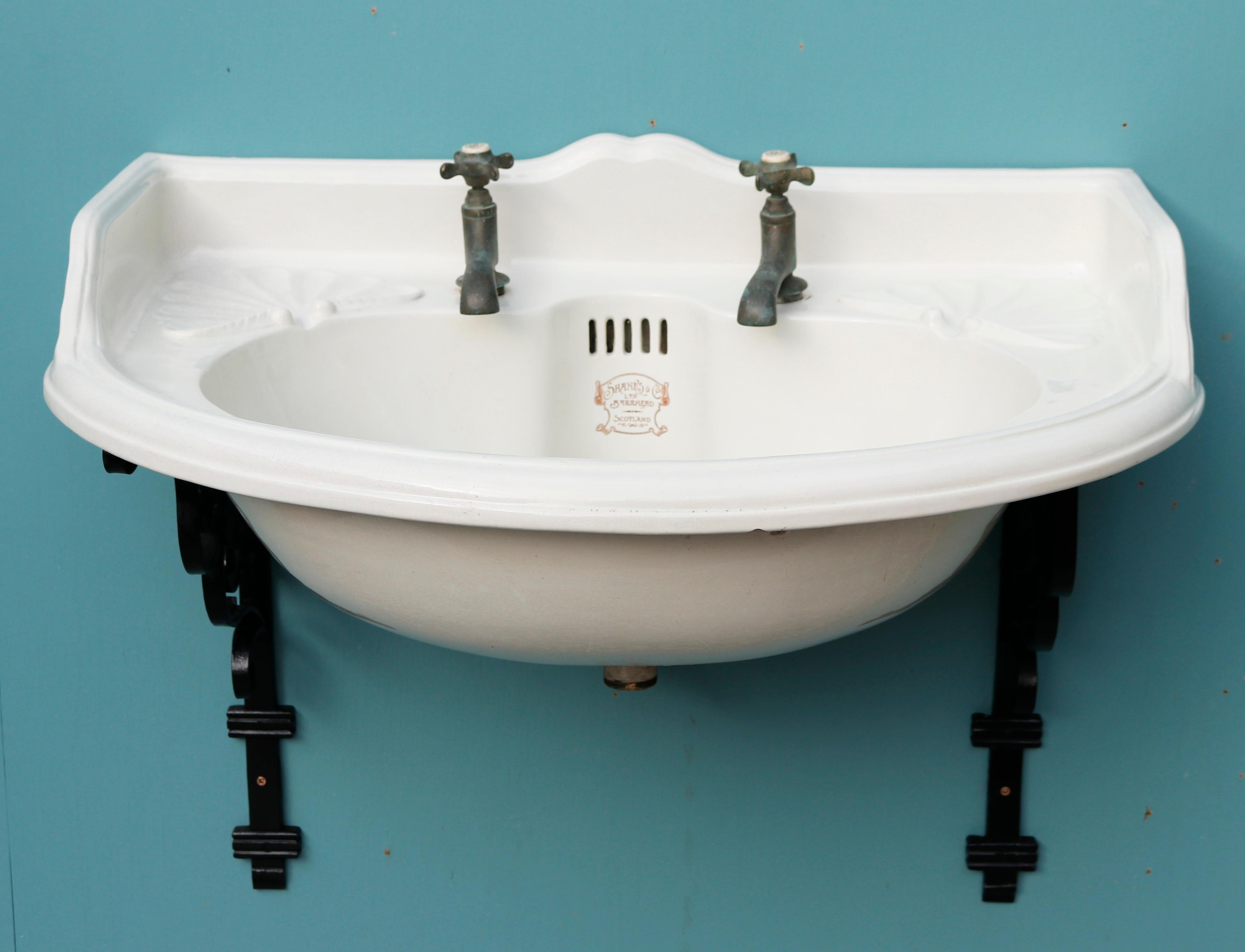 A Shanks bow fronted porcelain sink with a pair of wrought iron wall mounting brackets. A lovely basin, very scare in this size and condition.