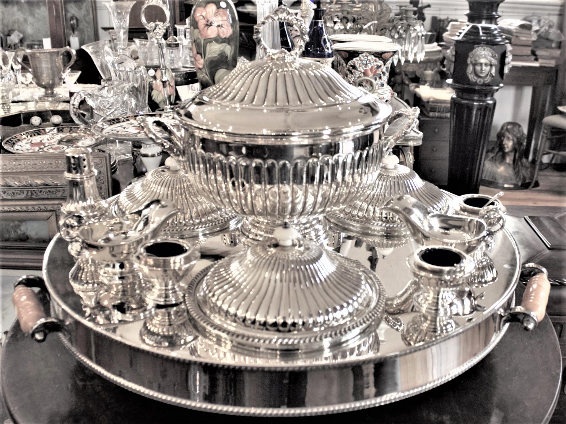 This very large and substantial antique silver plated carousel or 'Lazy Susan' server was made in Sheffield England in circa 1920 in a slightly earlier Edwardian style. The base is a very heavy silver plated hot water tank with a large drain plug