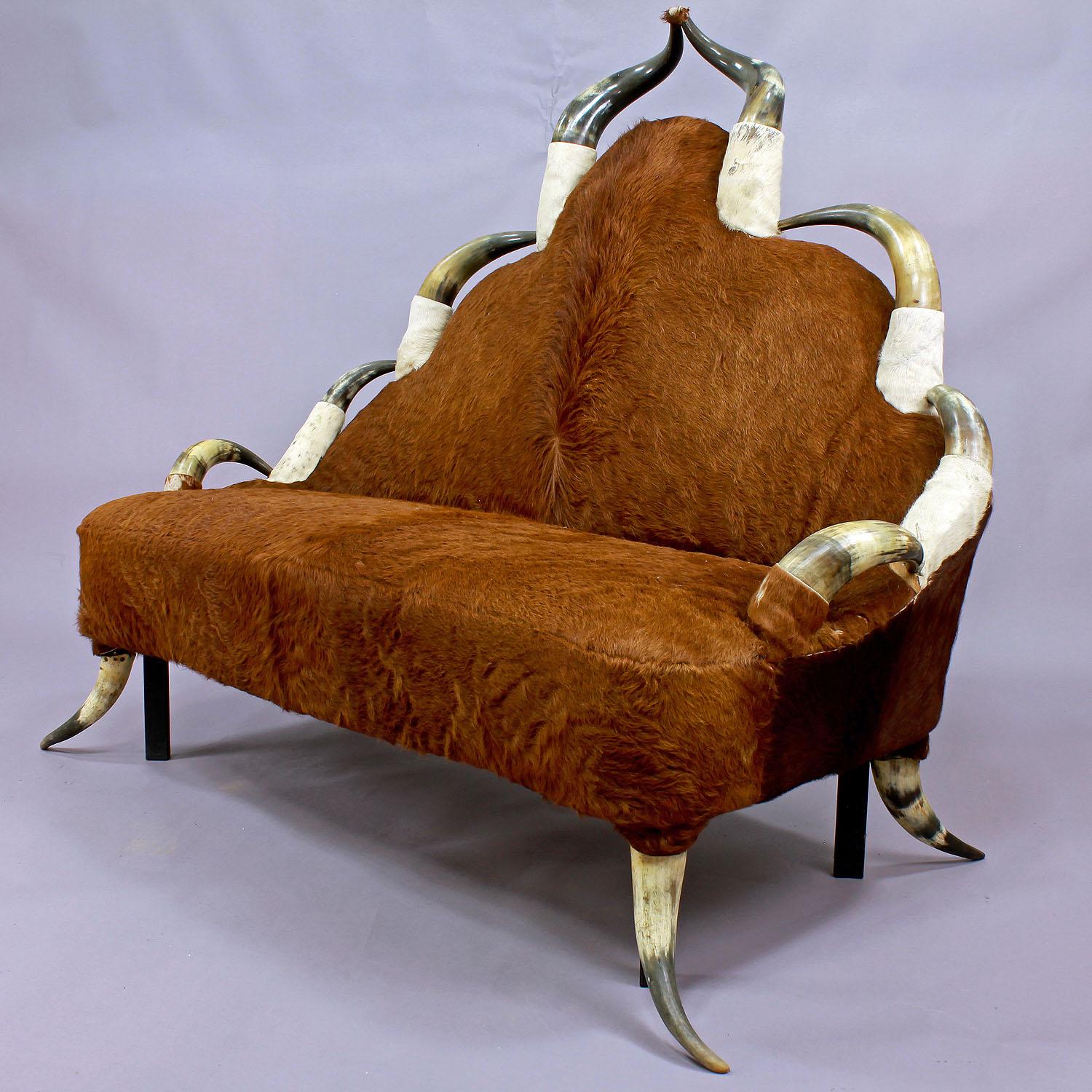 Ein großes Stierhorn-Möbelsofa, um 1870, verziert mit einer Reihe von antiken langen Hörnern und bezogen mit Vintage-Kuhfell (muss erneuert werden, verliert die Haare). Die Eisenbeine verbessern die Stabilität. Hergestellt in Österreich, um