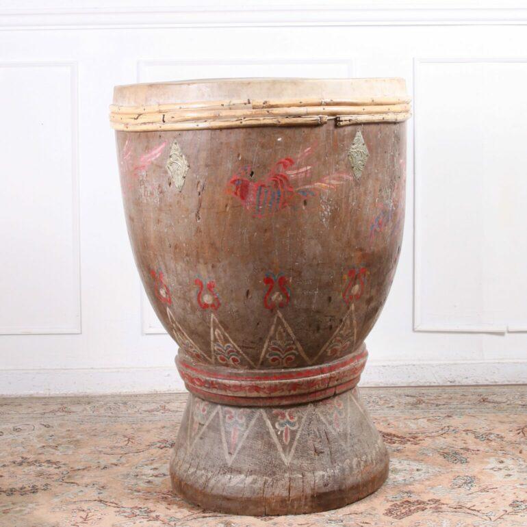 A large antique South East Asian wooden ceremonial drum with leather drumhead. With a natural finish, beautifully aged patina, and a circular flared base, this drum will make for a great decorative accentuation in any home and a strong conversation