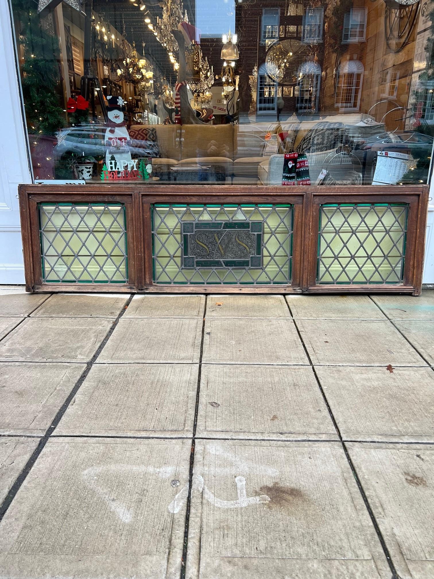 Antique stained glass transom in a wood frame with the initials SVS in the center. This is large stained glass transom window imported in from Brussels Belgium. It's in good condition no cracks in the glass and a very sturdy thick heavy frame. There
