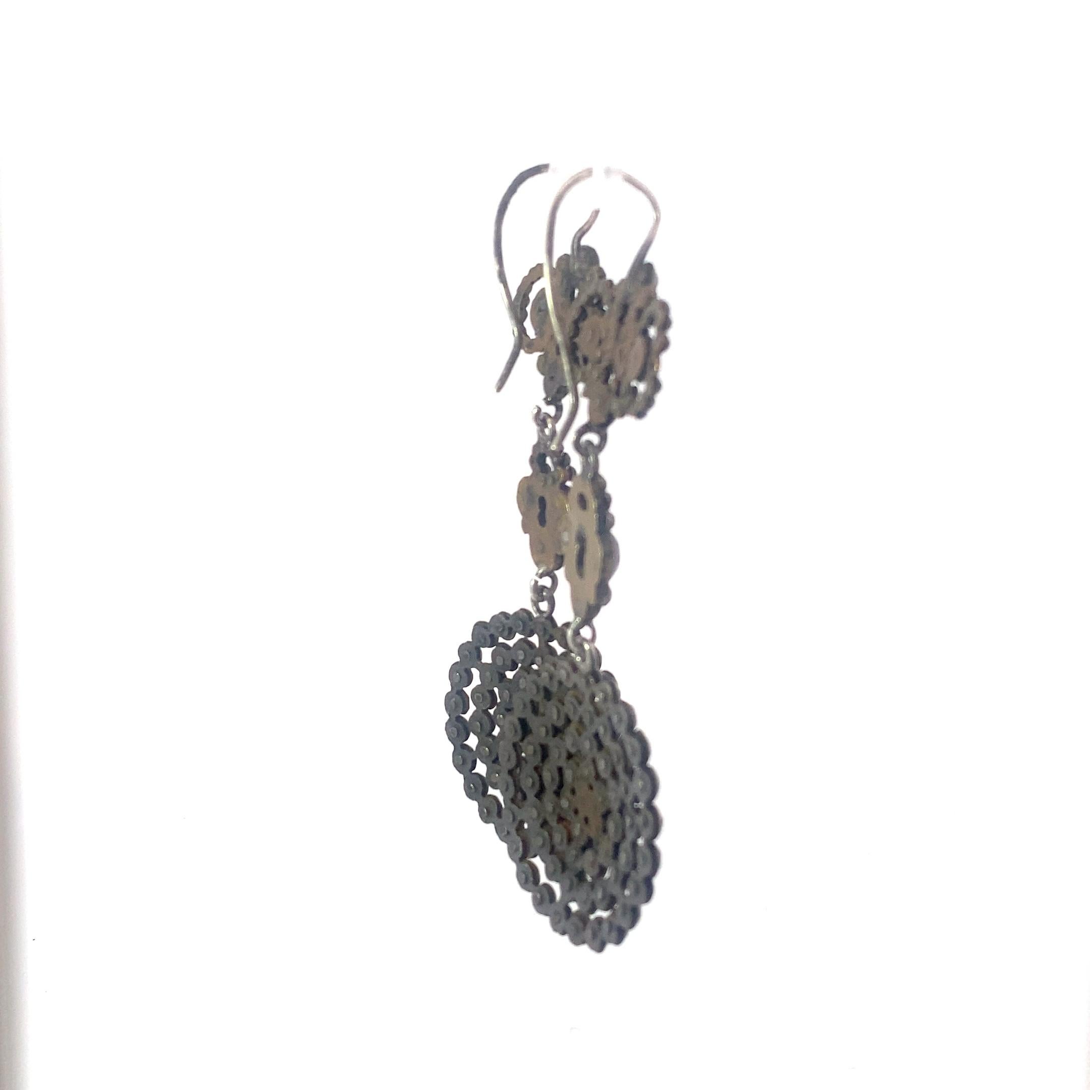 these large cut steel drop earrings make a large statement. Dating from the late Victorian period these earrings features three distinct segments, the largest of which an approximately 1 inch diameter round arrangement of cut steel beads. 