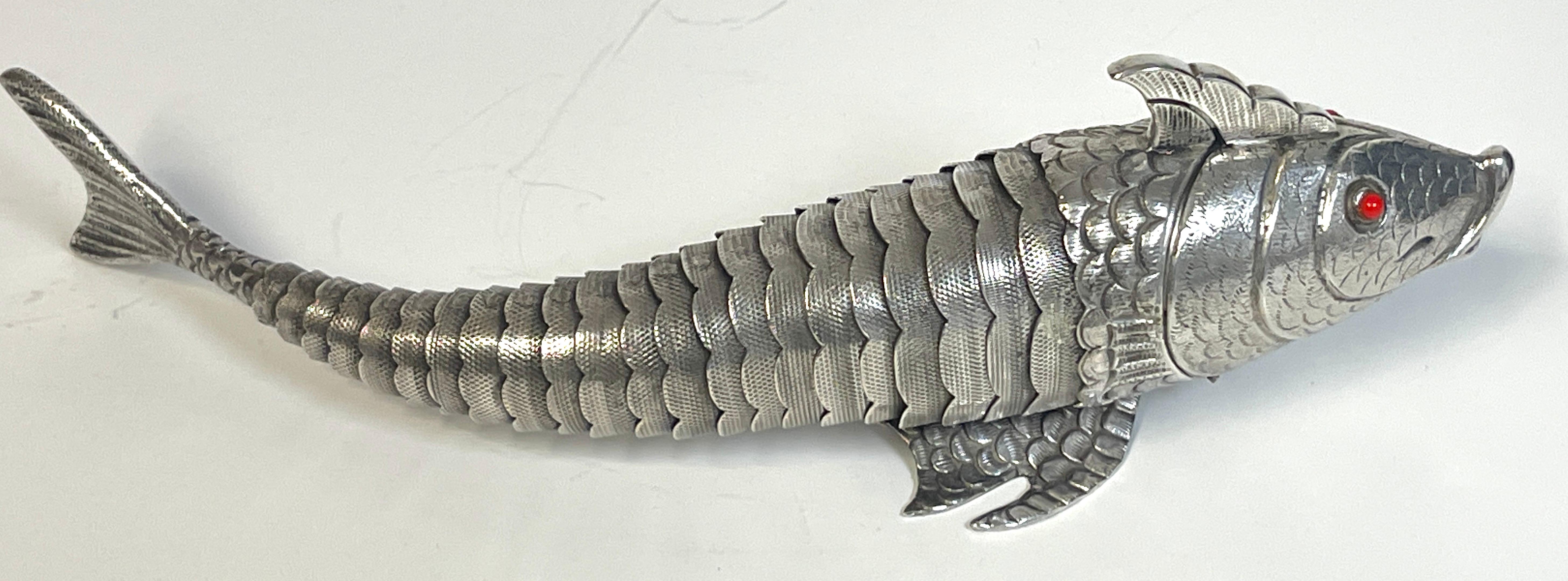 Large antique sterling articulated fish spice box, Portugal, circa 1900
Finely chased and modeled, with inset coral eyes. 
The hinged head reveals the interior of the box. Hallmarked and stamped 'Silver Made in Portugal' 
With seamless