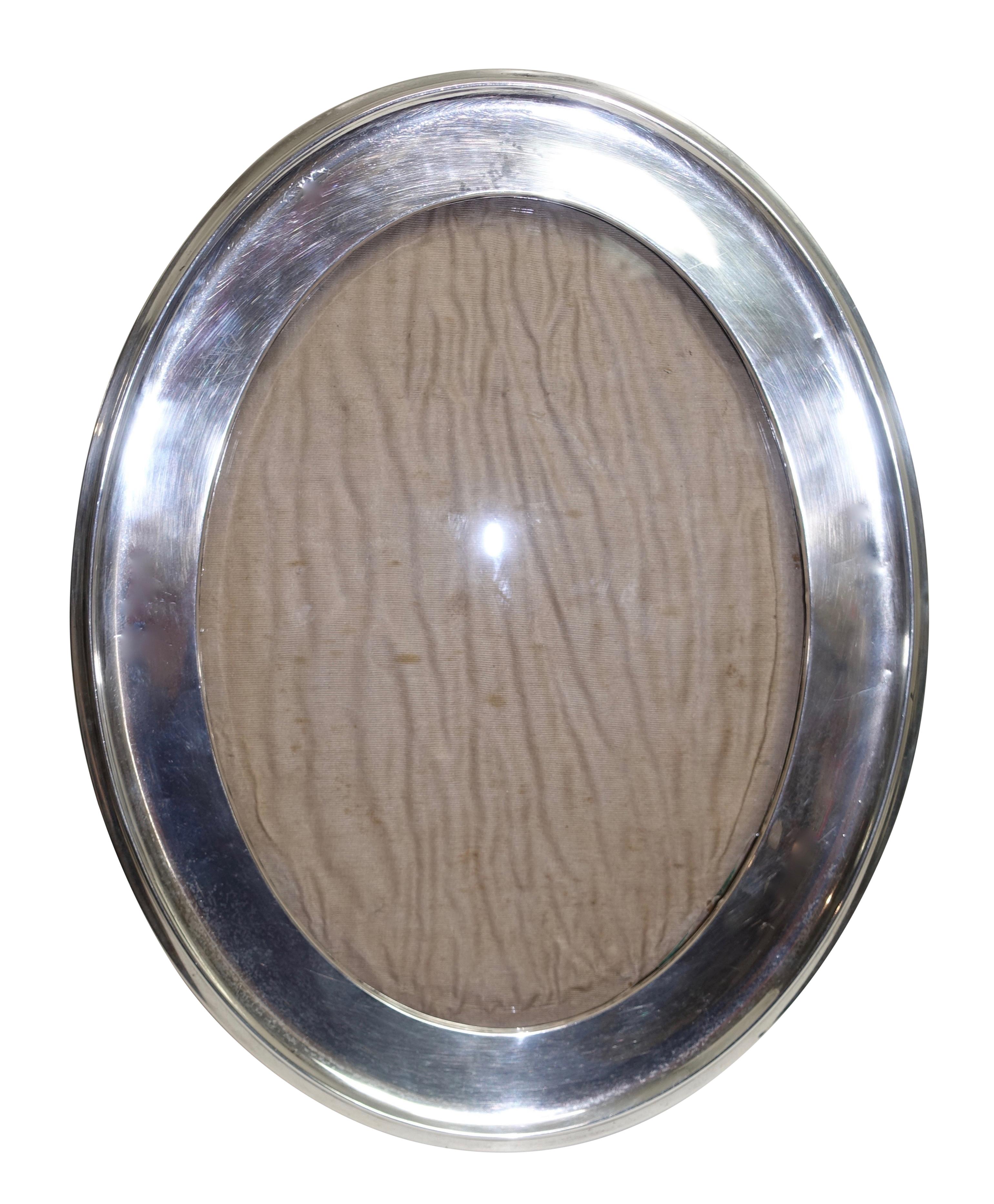 An unusually large oval shape sterling table top photo frame with oak easel back. England, circa 1920.
The inner sight of the frame measures 9.75 high x 7 wide.
Shows minor light dings and dents.