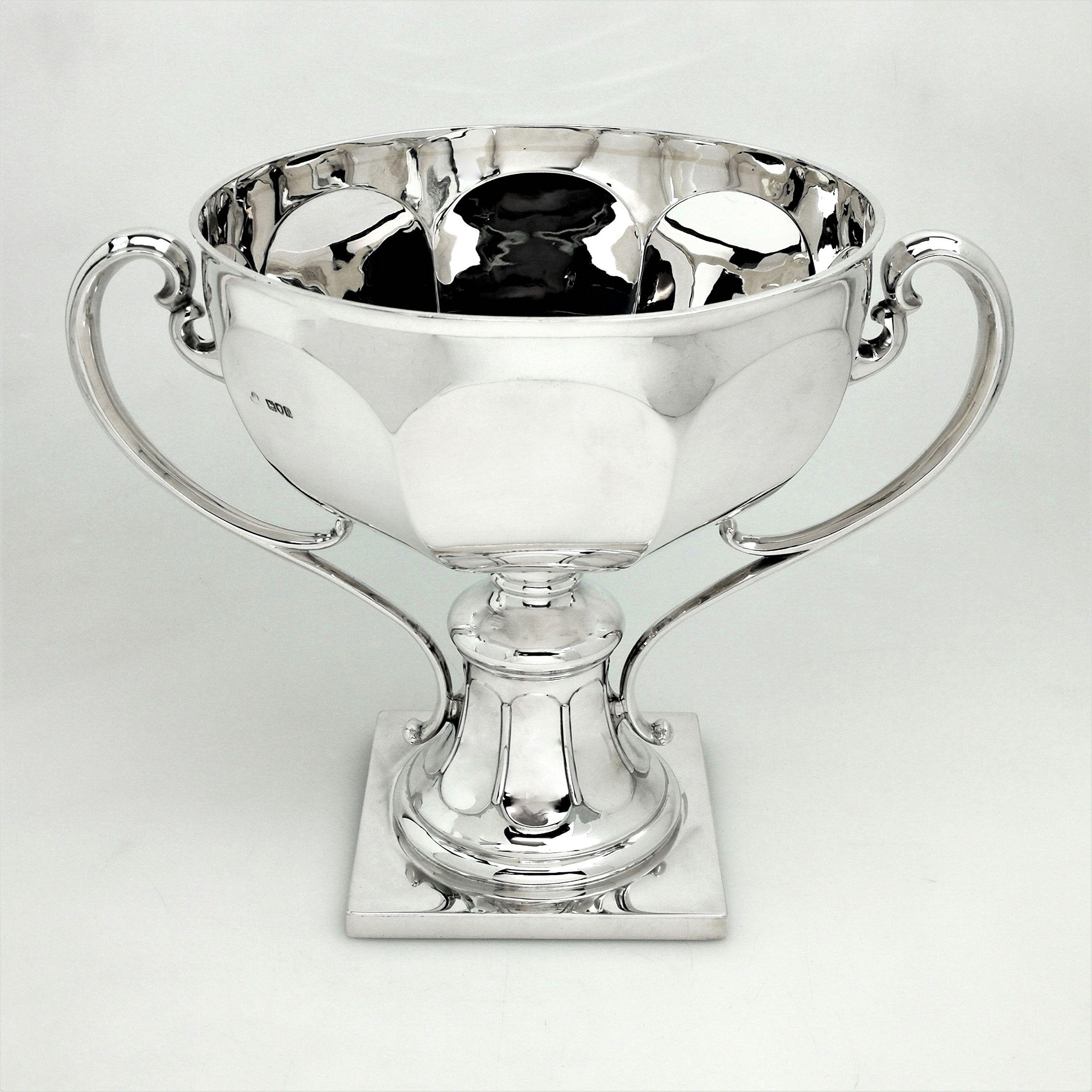 A magnificent large Antique Silver Trophy with a large panelled bowl, two impressive scroll handles and standing on a sturdy silver base. The Trophy is polished silver and suitable for engraving if desired.
 
Made in London in 1910 by Manoah Rhodes