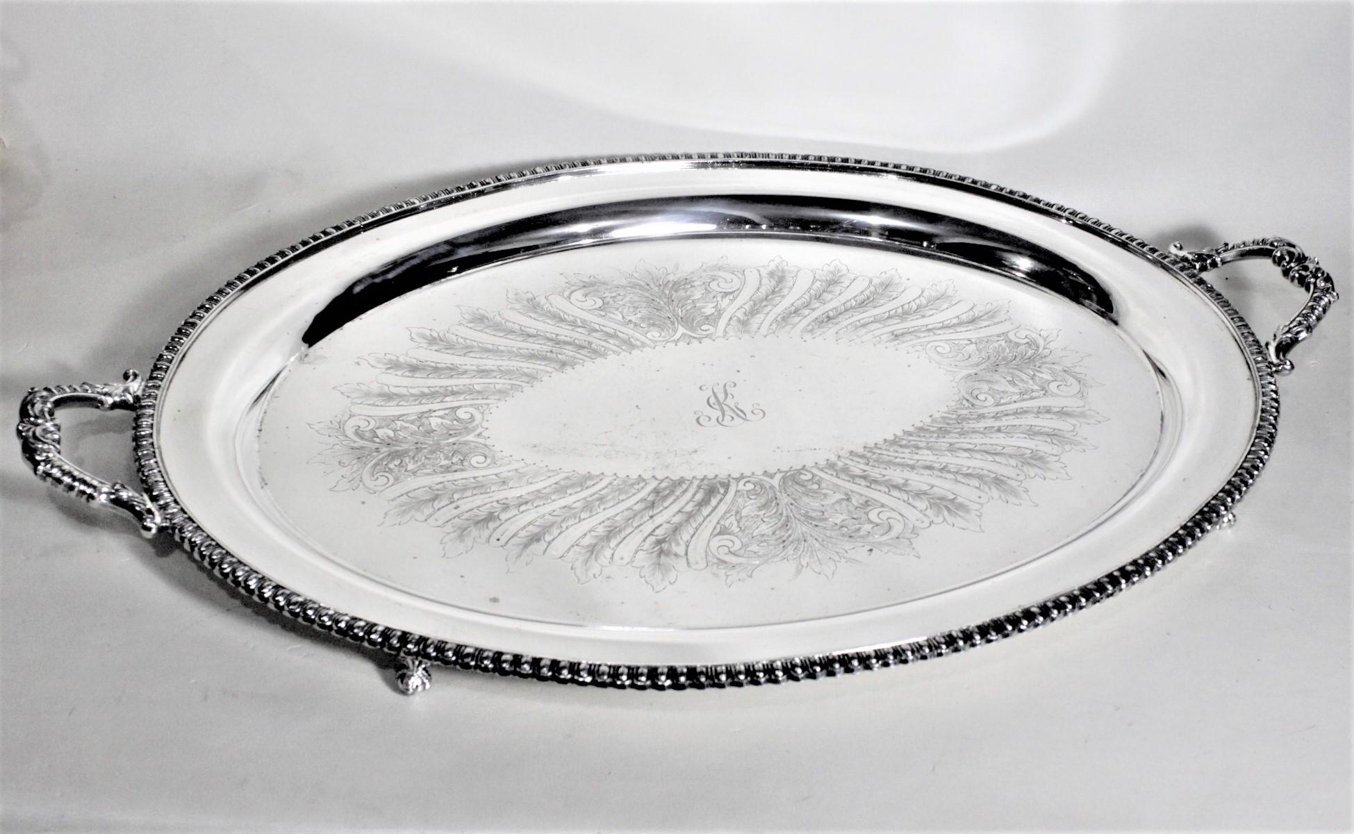 This large antique styled silver plated serving tray is hallmarked by an unknown maker, and presumed to have been made in England in approximately 1920 in an Edwardian style. The tray is silver plated over copper and has a nicely beaded surround and