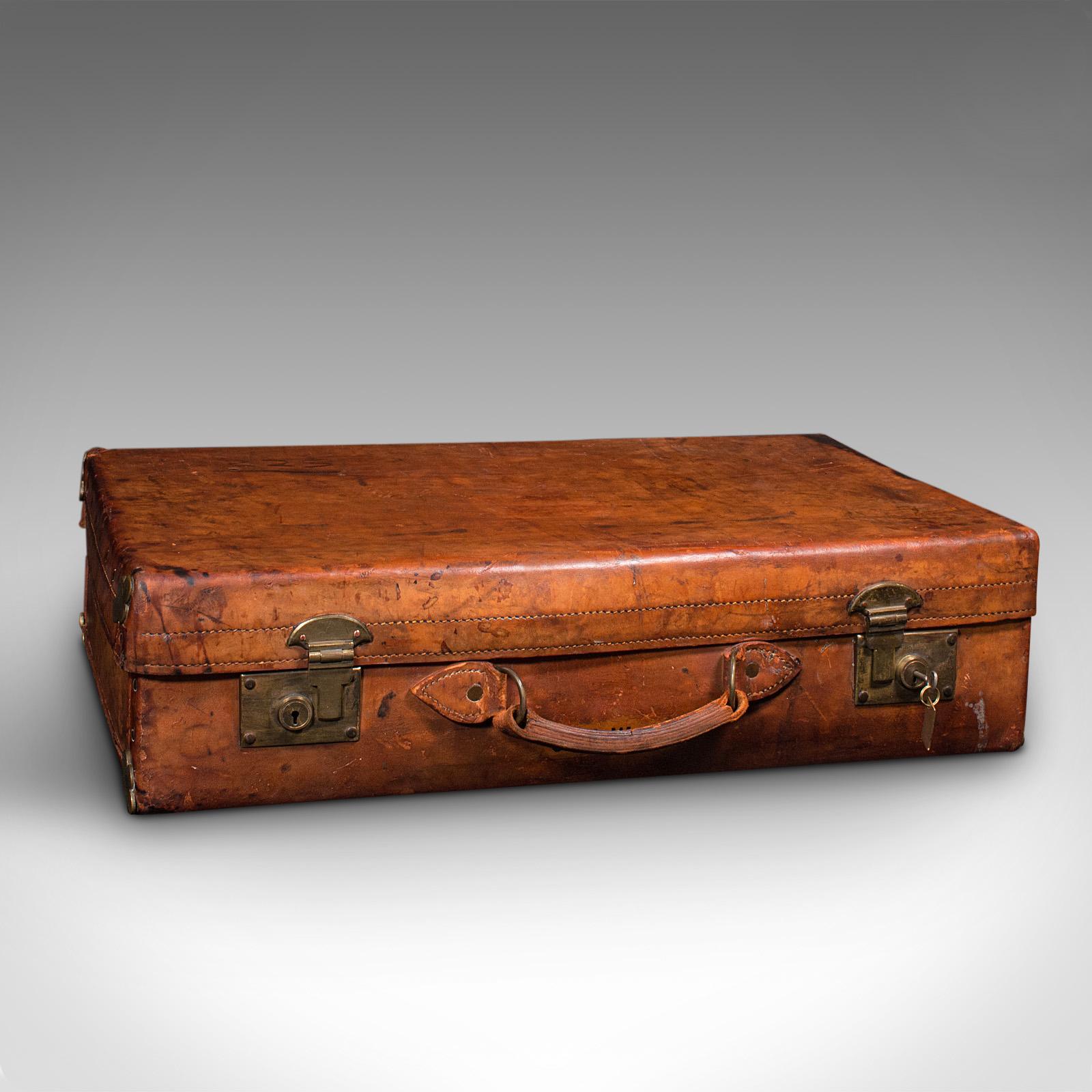 Il s'agit d'une grande valise ancienne. Une mallette de voyage anglaise en cuir et laiton pour gentleman, signée Tom Hill - Sloane Street, datant de la période édouardienne, vers 1910.

De taille et de finition superbes, cette mallette est un