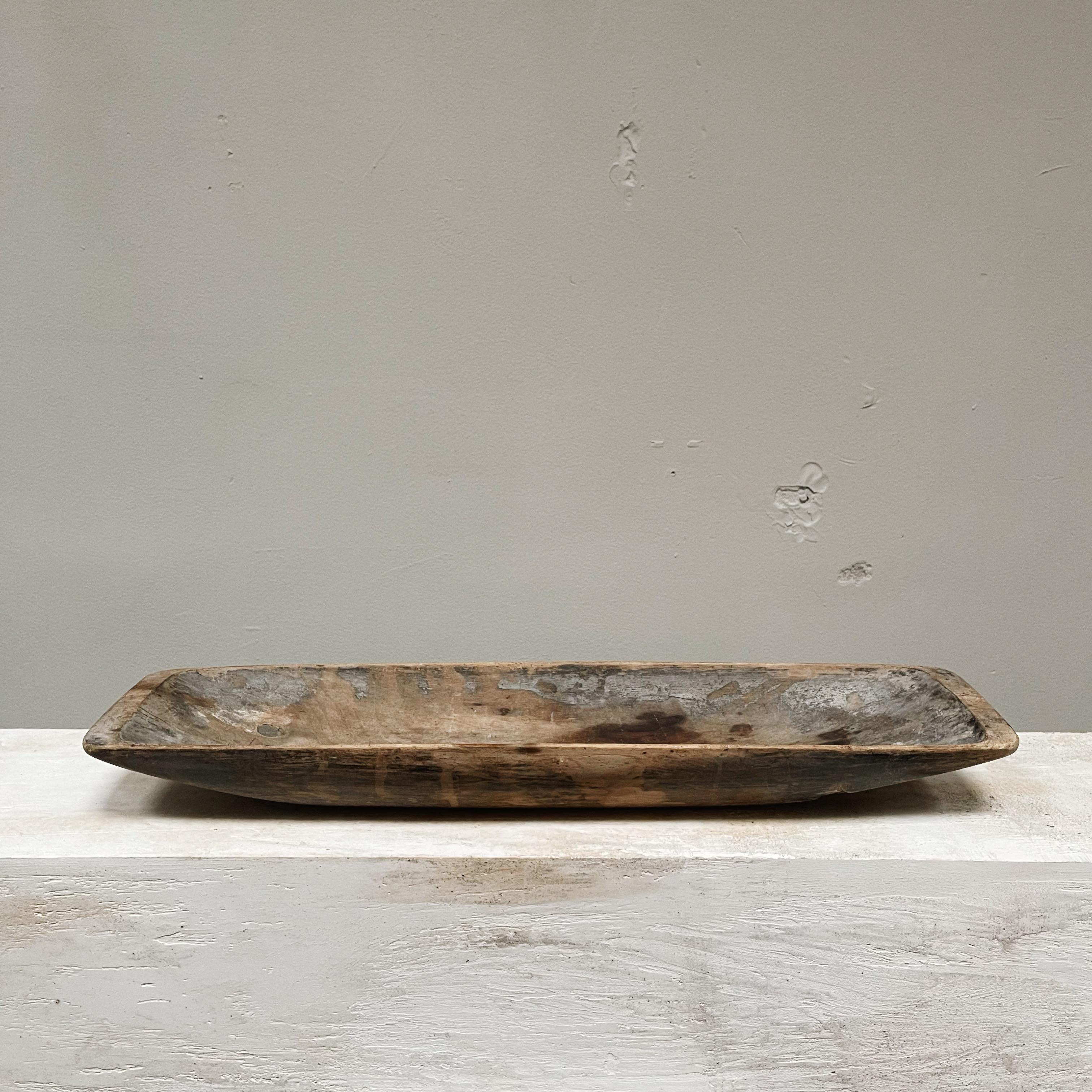 Antiguo comedero de madera de la Suecia del siglo XIX, tallado a mano y de autenticidad única, con una marca de propiedad en la base. Esta pieza presenta muchos signos de su antigüedad, con una pátina increíblemente bella que refleja su larga