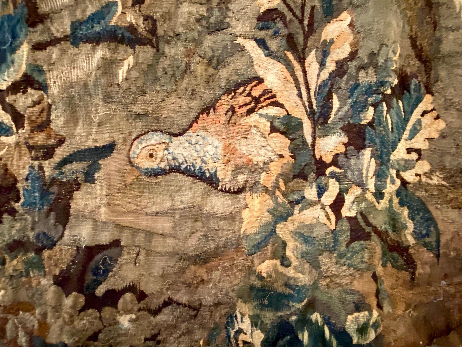 Ein antiker französischer Verdure-Wandteppich aus dem 18. Jahrhundert, der eine Stadt auf einem Hügel, Bäume und Tiere zeigt.

Abmessungen:
Höhe: 88