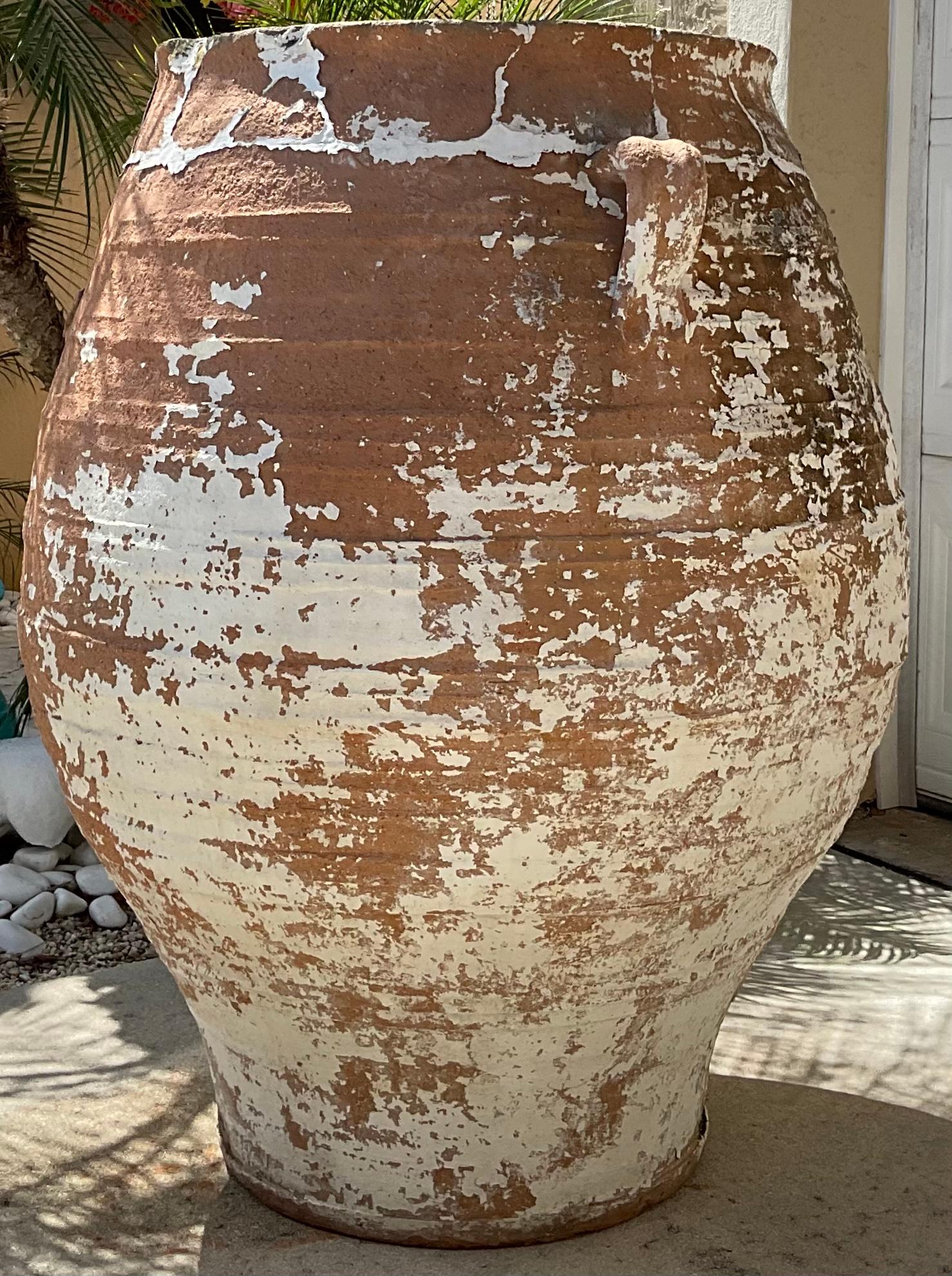 An antique terracotta jar in grand scale ,with beautiful aged patina two side handles, the third one is missing. Good condition even though the repairs that has been done through the years.
Still beautiful and dramatic large object of art for