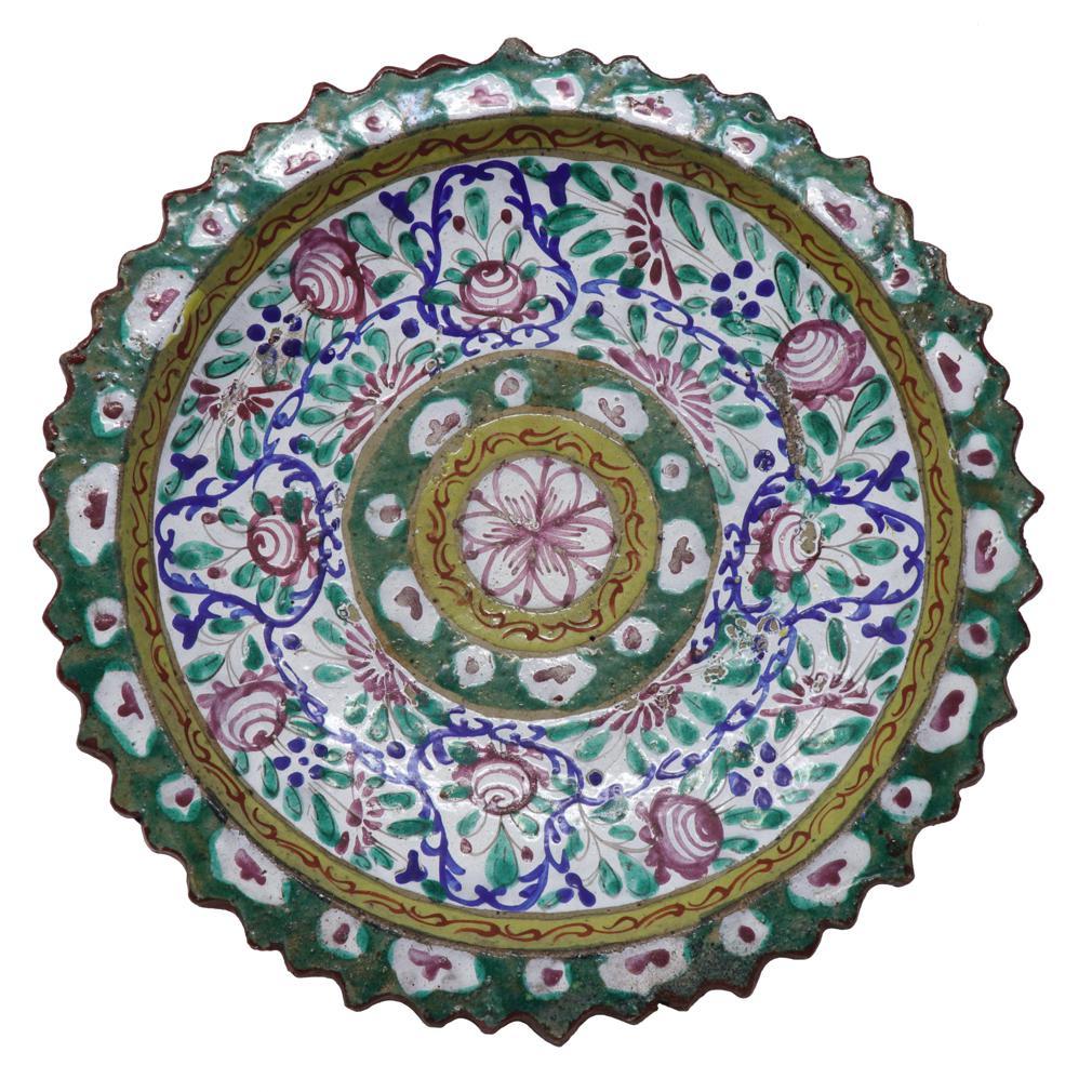 Large Antique Thai Bencharong Stem Plate. A stoneware tazza having a domed pedestal base under a foliate rim dish. Traditionally enameled in a green and yellow palette with accent colors of purple, red, blue and white in a circular floral decoration