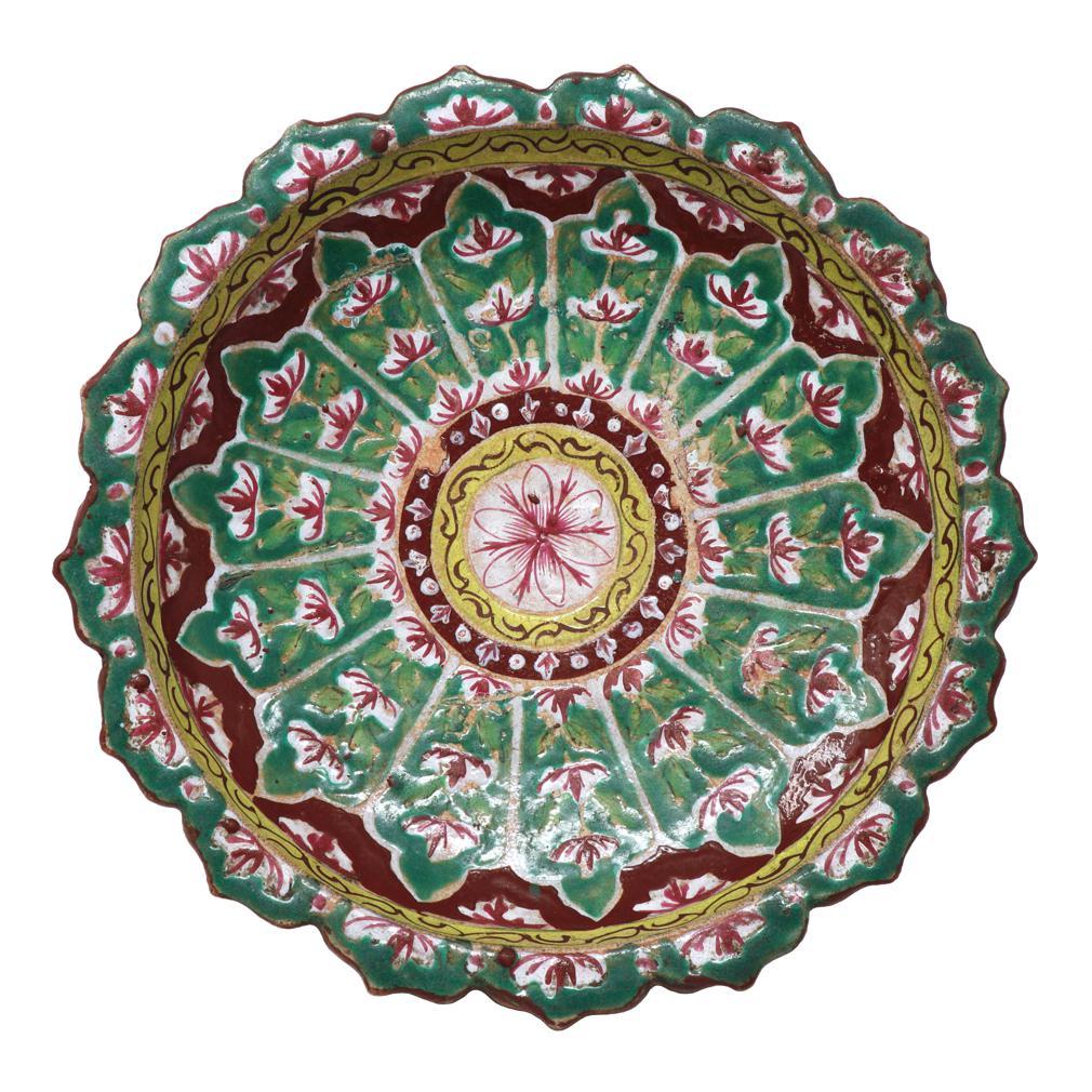 Large Antique Thai Bencharong Stem Plate. A stoneware tazza having a domed pedestal base under a foliate rim dish. Traditionally enameled in a green and red palette with accent colors of yellow and white in a circular radiating floral decoration
