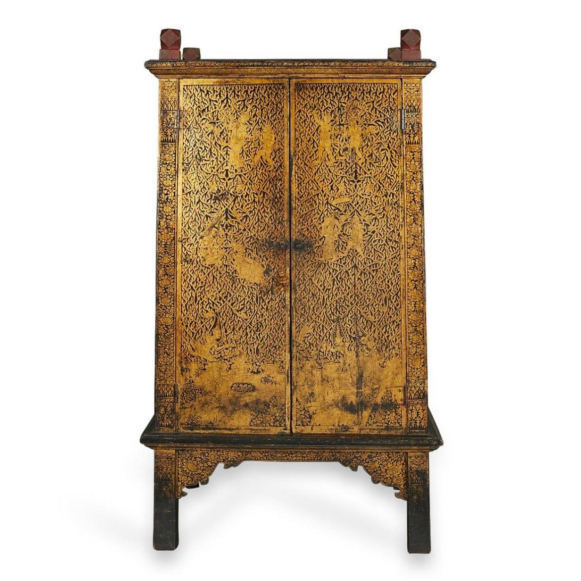Large Antique Thai Buddhist Manuscript Storage Cabinet. A tapering upright cabinet made of teak with black lacquered exterior and red interior. The decoration of gold on a black ground on three sides is created by the Lai Rot Nam tradition of