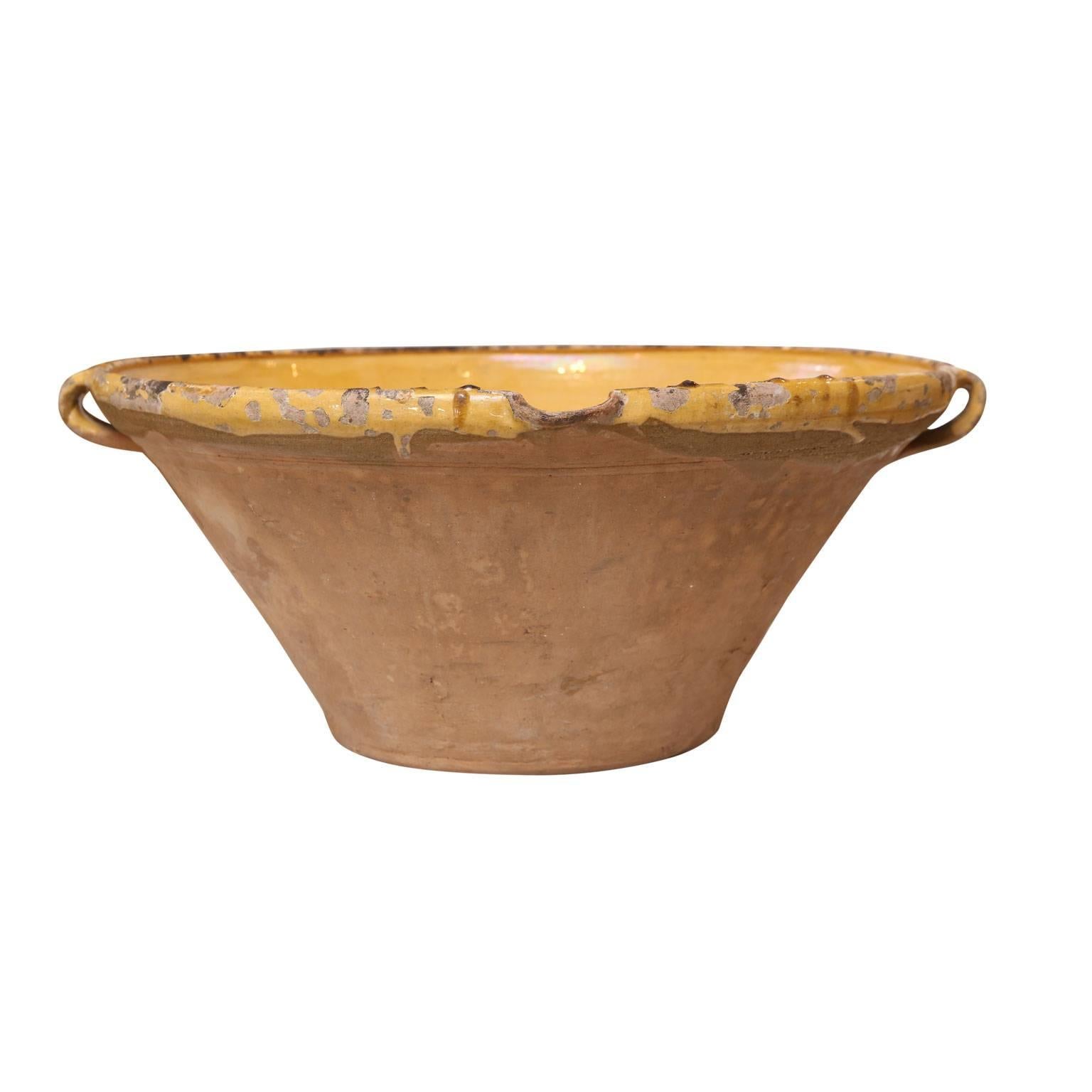 Large antique tian from Provence. This beautifully shaped larger-than-average earthenware bowl features small handles, tapered pour spout and subtle yellow glazed interior and rim. In the 19th century, this French bowl served a utilitarian purpose: