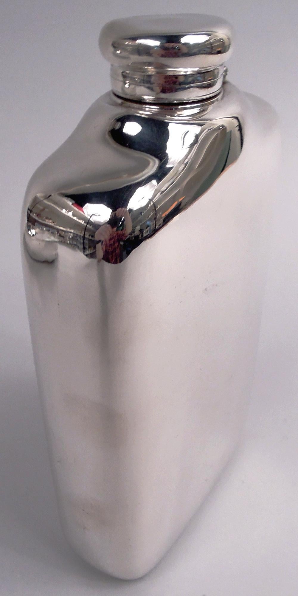 Gran petaca victoriana de plata de ley. Fabricado por Tiffany & Co. en Nueva York, hacia 1883. Rectilínea con lados curvos y parte superior elevada y perfilada; tapa abatible y forrada de corcho. El modelo alfa de dos manos con mucho espacio para
