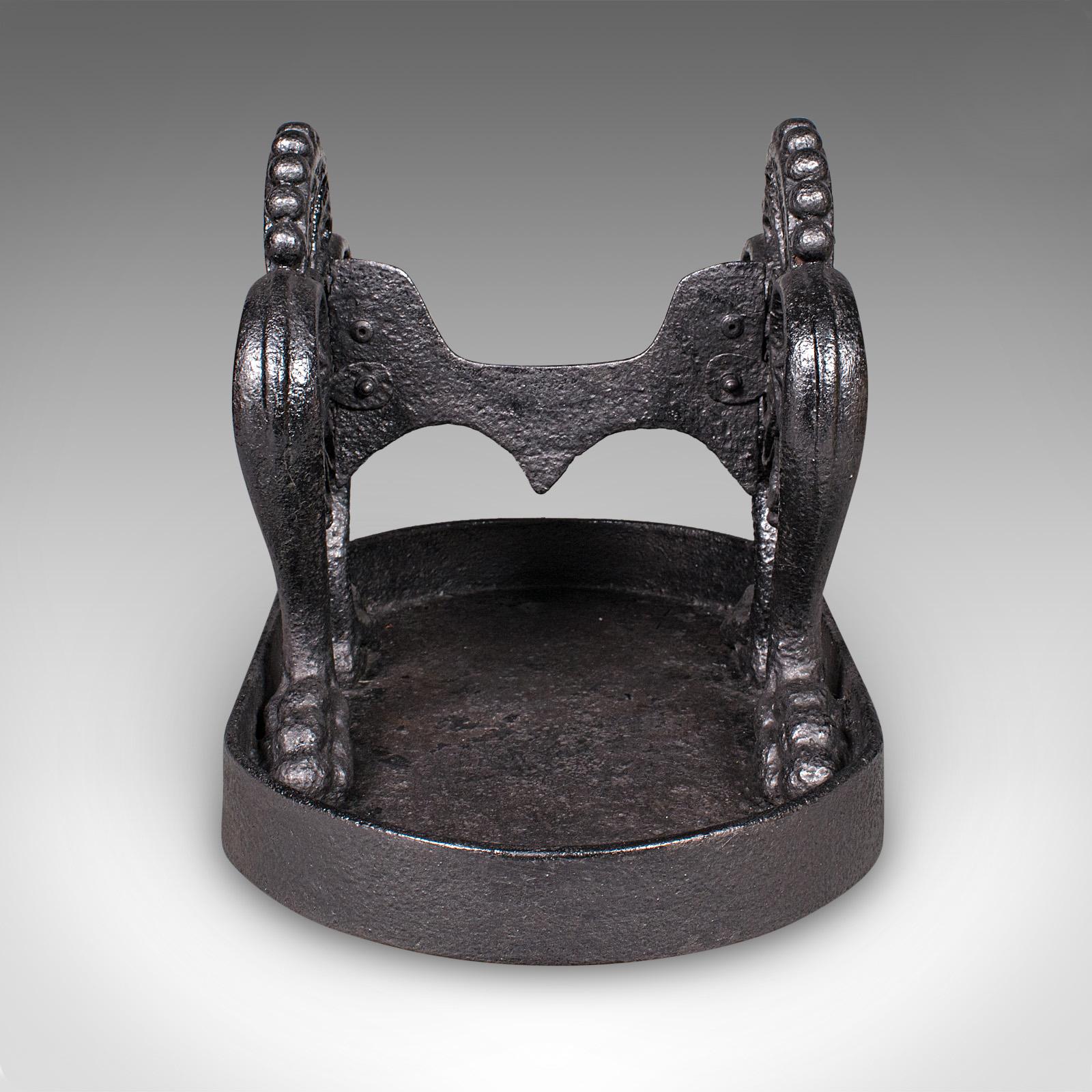 This is an antique townhouse boot scraper. An English, cast iron shoe pull, dating to the early Georgian period, circa 1750. A superbly proportioned and weighty entranceway piece, offering both functional charm and striking decorative
