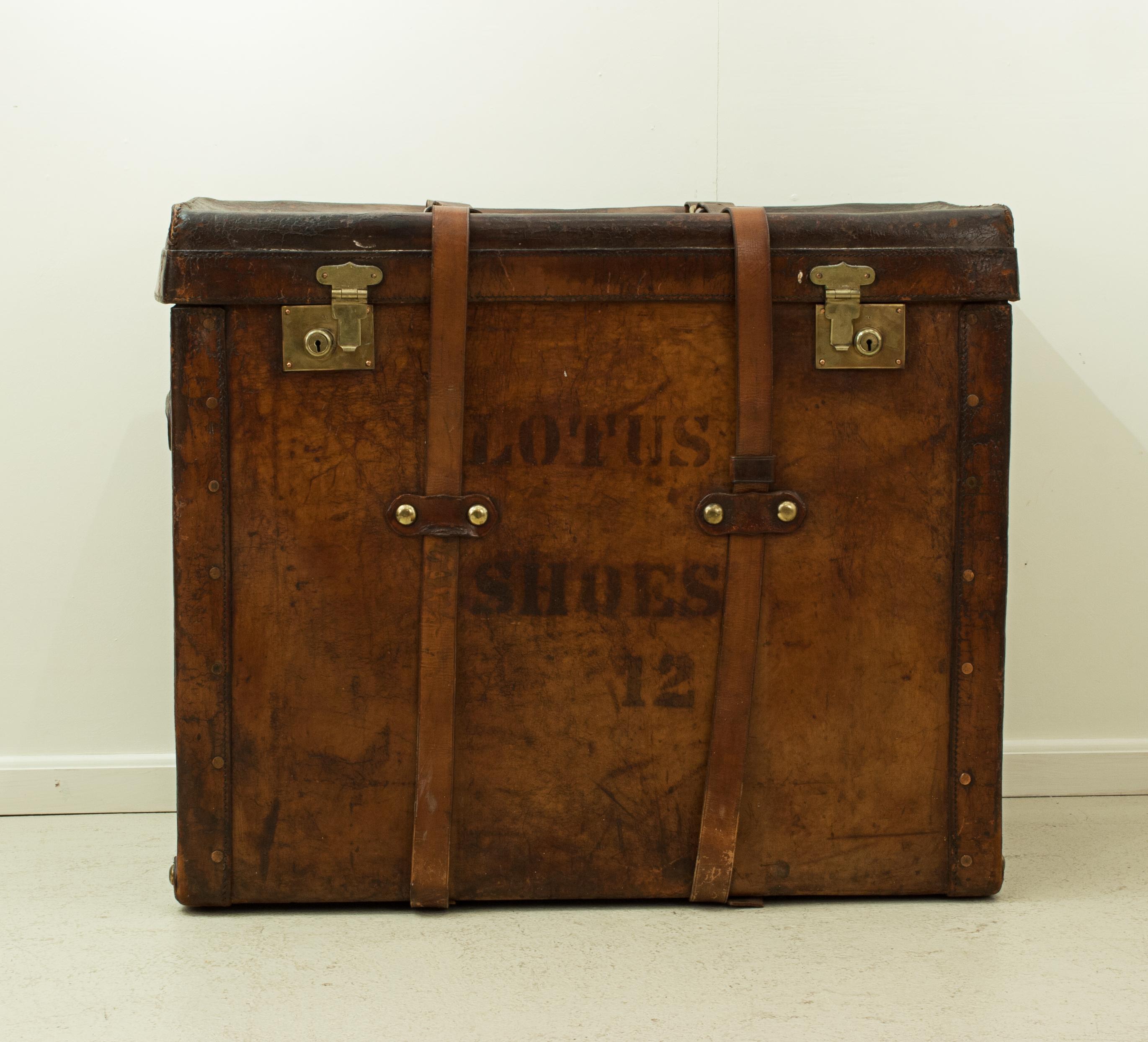 Large leather traveling trunk
An unusual leather trunk for the storage of shoes, painted to the front and back 'Lotus Shoes 12'. The case with two leather carry handles, one either end, brass locks and two leather straps. The strap stamped 'D.