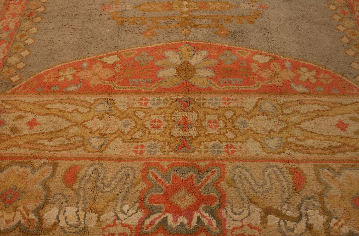 This is an extra-large antique Izmir carpet woven in Turkey during the first quarter of the 20th century circa 1920's and measures 565 x 360CM in size. This carpet has an open field design with semi-circle motifs located at each end of the field.