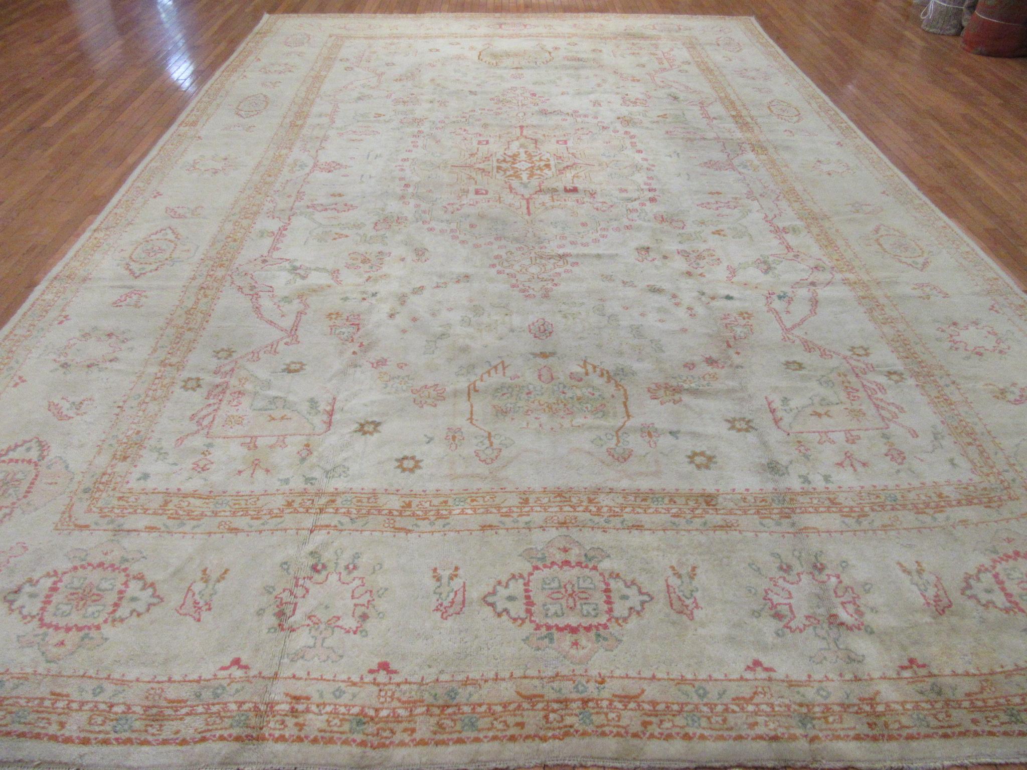 This is a beautiful antique hand-knotted Turkish Oushak rug. It has an exquisite formal design made with all wool colored is all natural dyes. The rug measures 11' 9'' x 18'. It is in great condition.
 