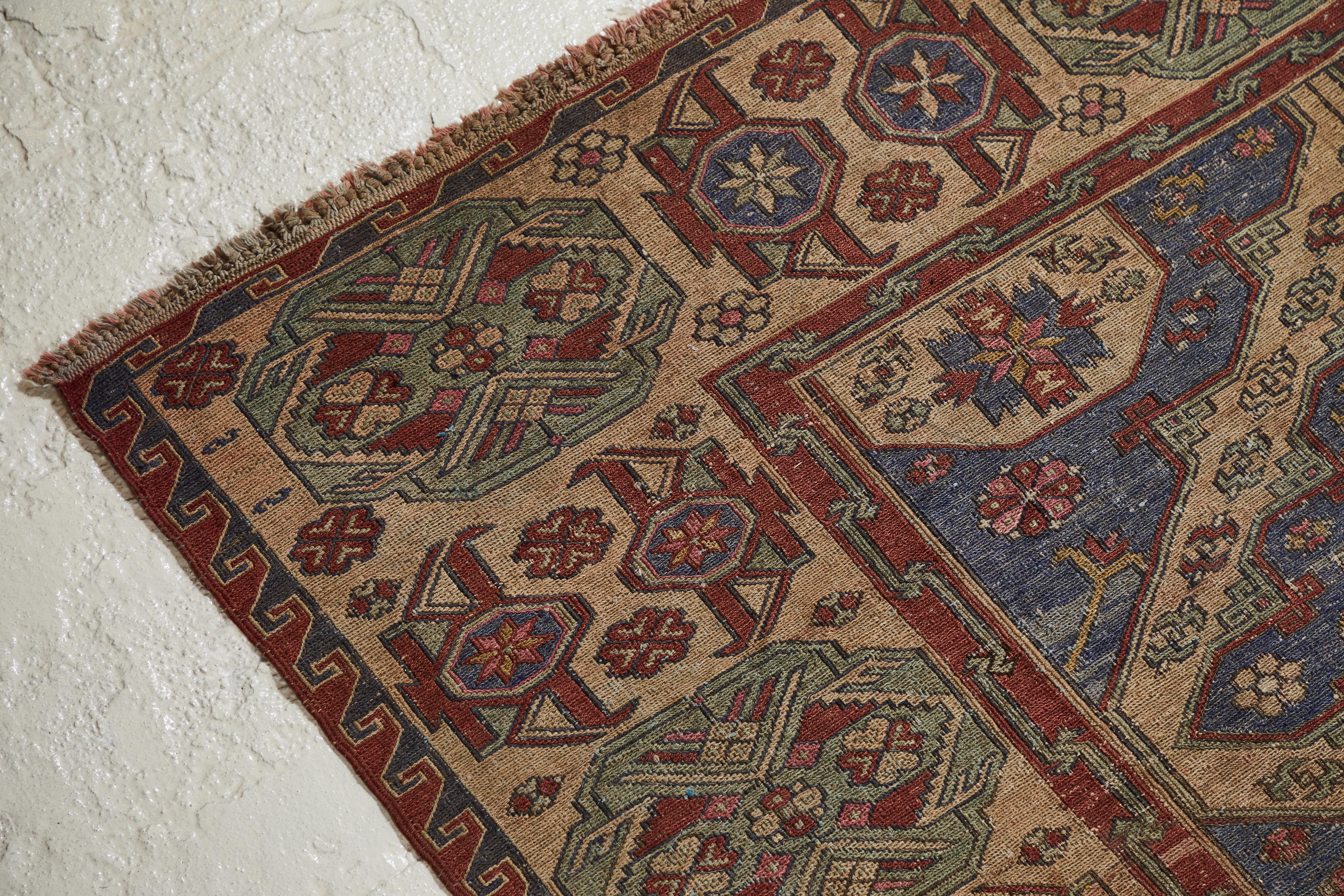 Beautiful large Caucasian rug with a unique and intricate pattern, the rug is worn and aged beautifully. The rug has shades of blue, red, natural and pink.