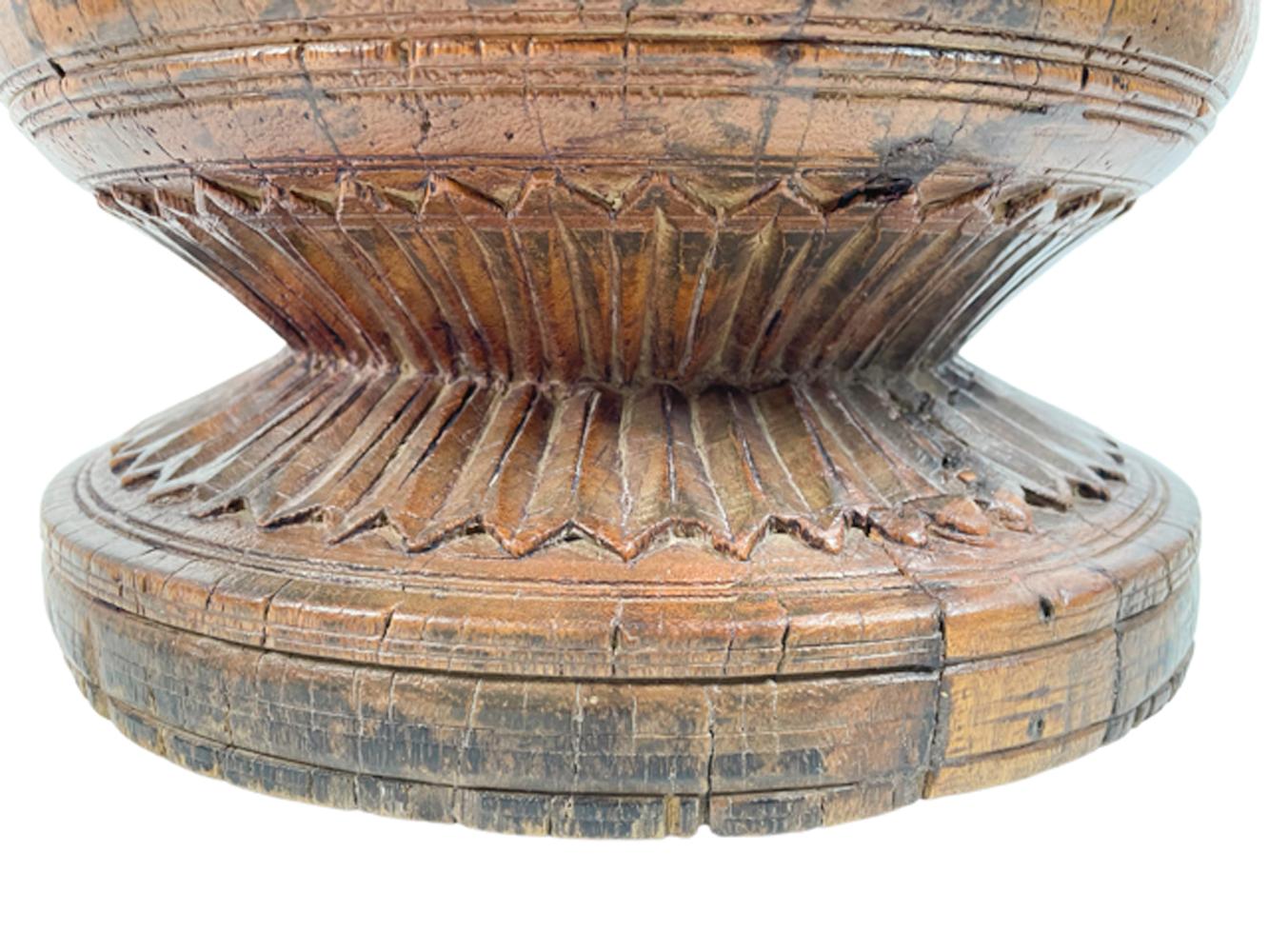 Exceptionally large eighteenth century turned Lignum Vitae mortar having a ring turned cylindrical bowl with a conforming foot and having a double band of palmettes carved on the top of the foot and bottom of the bowl.