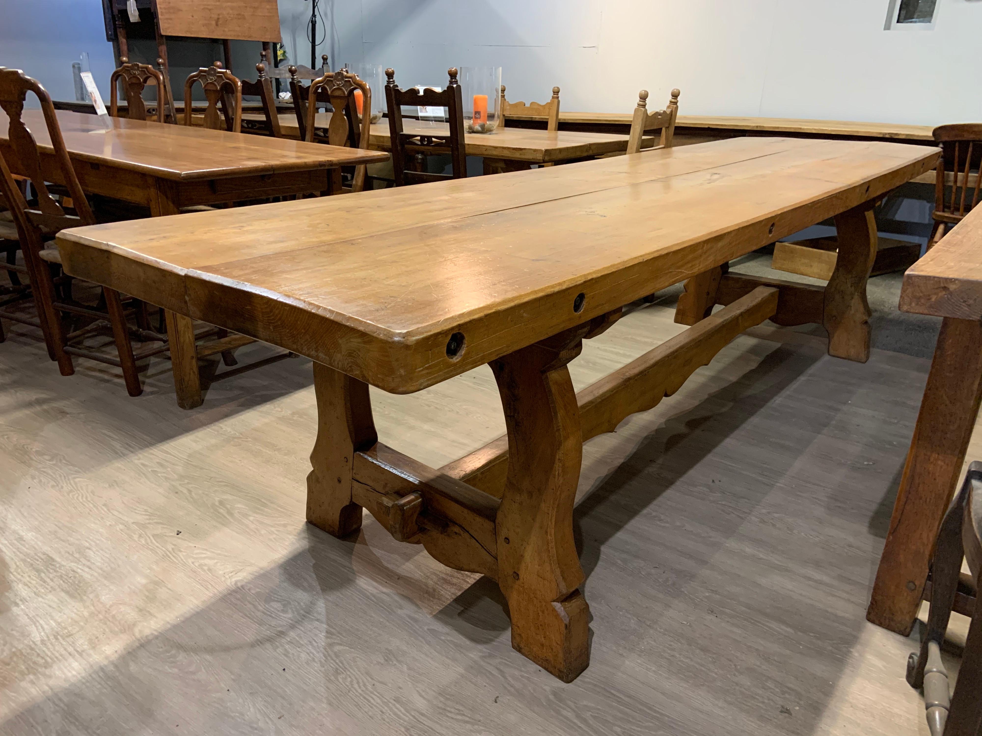 Large antique elm twin plank Alpine trestle table with 3” thick top and sits on end trestles with centre stretcher.