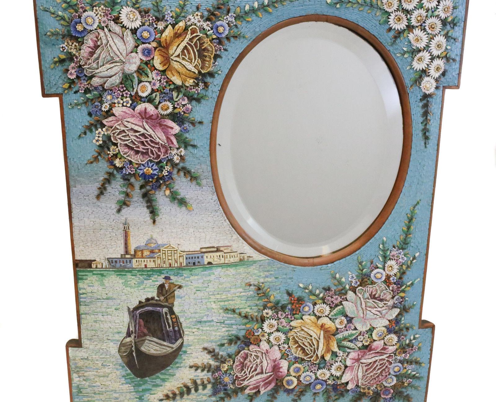An exquisite antique Venetian micromosaic wall hanging mirror. The mirror has stunning micromosaic tiles depicting the Grand Canals in Venice, Italy with floral accents. An oval shaped mirror to the upper right. Weight Approx., 15