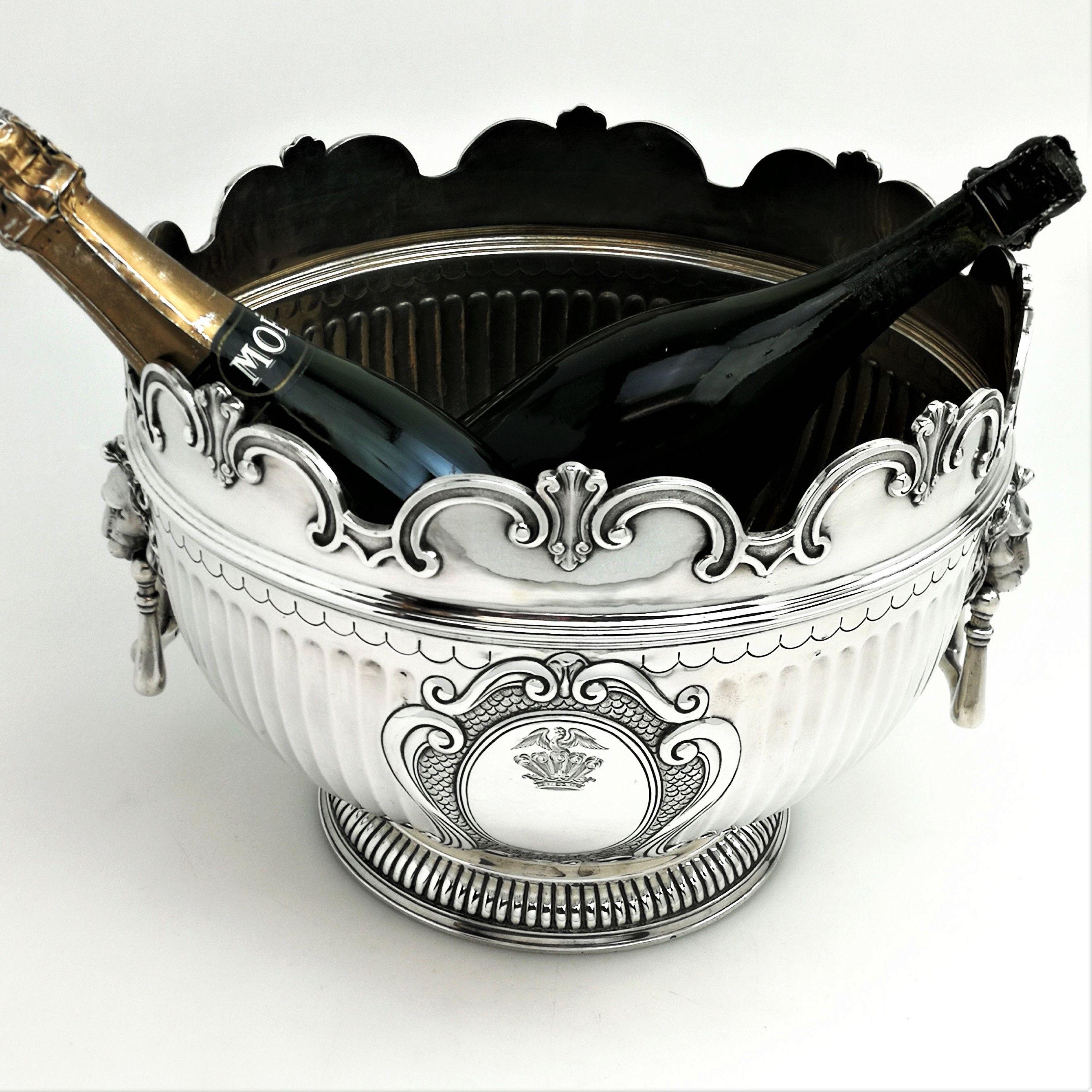 A magnificent antique Victorian sterling silver Monteith style bowl. This bowl is large enough to be used as a punch bowl or a champagne / wine cooler / ice bucket. The Bowl has a classic half fluted chasing and a pair of impressive lion head