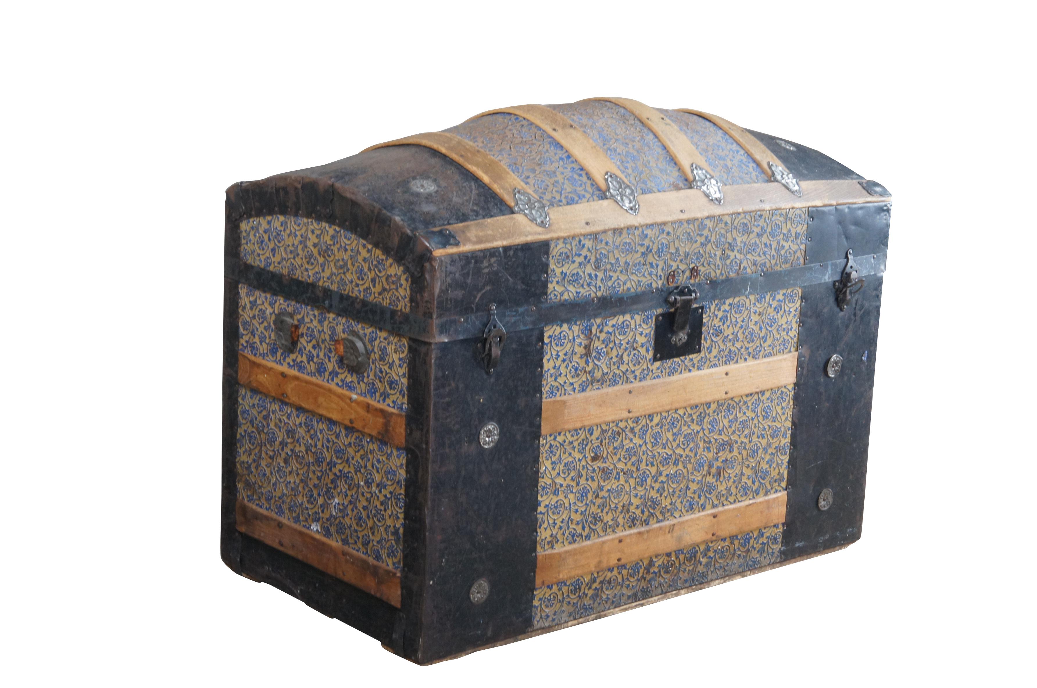 A large and impressive Victorian era dome top steamer trunk, circa 1870s. Features a tooled leather frame wrapped in black metal with oak banding and gold medallions.   Opens to two litho portraits on the lid and a compartment for additional