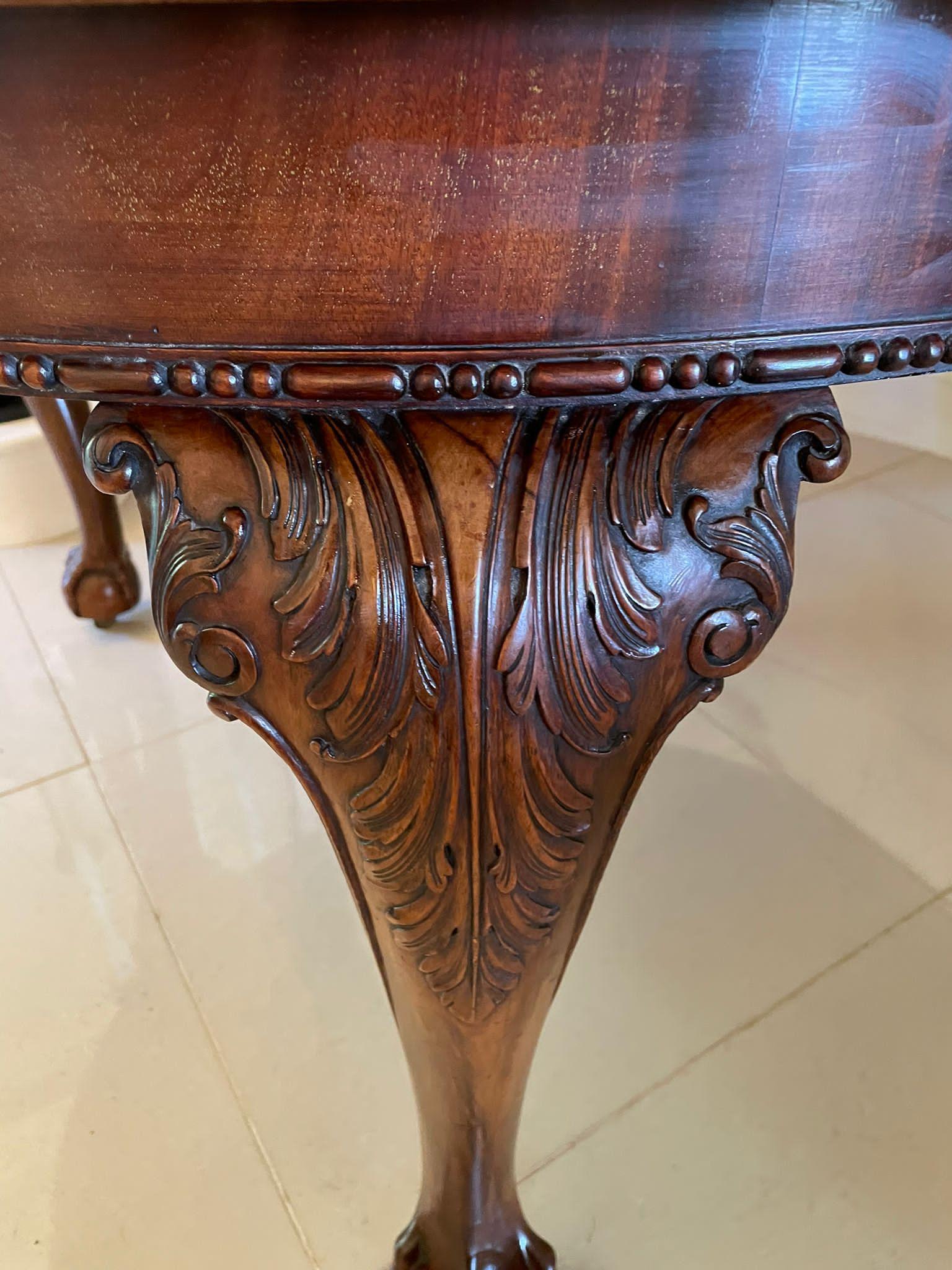 Large antique Victorian quality carved mahogany extending dining table having a superior quality mahogany top with a fabulous carved edge, mahogany frieze, two original extra leaves, original winding mechanism and handle. It stands on fantastic