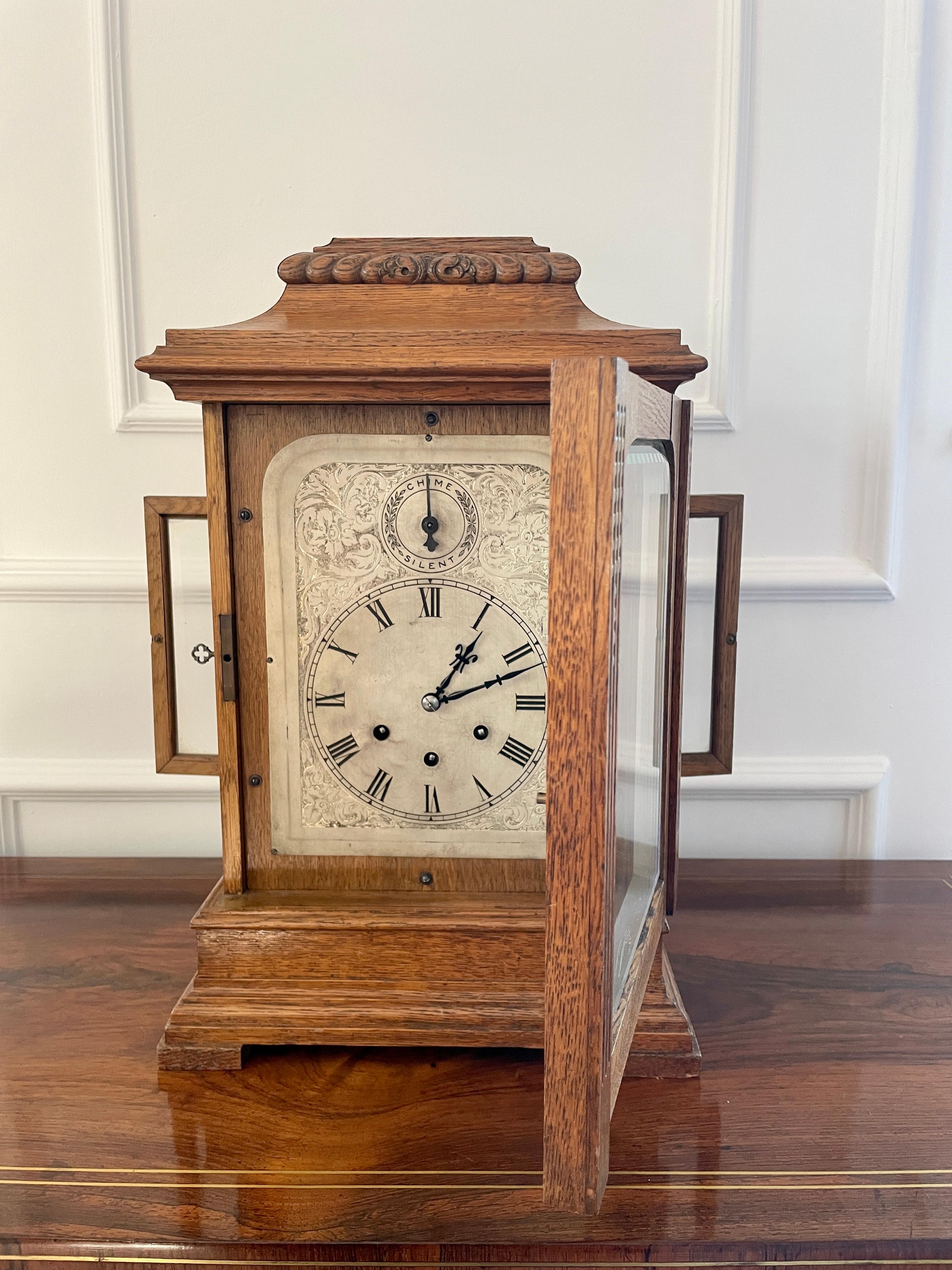 Large antique Victorian carved oak bracket clock with an eight day chiming movement, bevelled edged glass door opening to reveal an engraved silvered chapter ring with Roman numerals with original hands and a chime/ silent dial, eight day movement