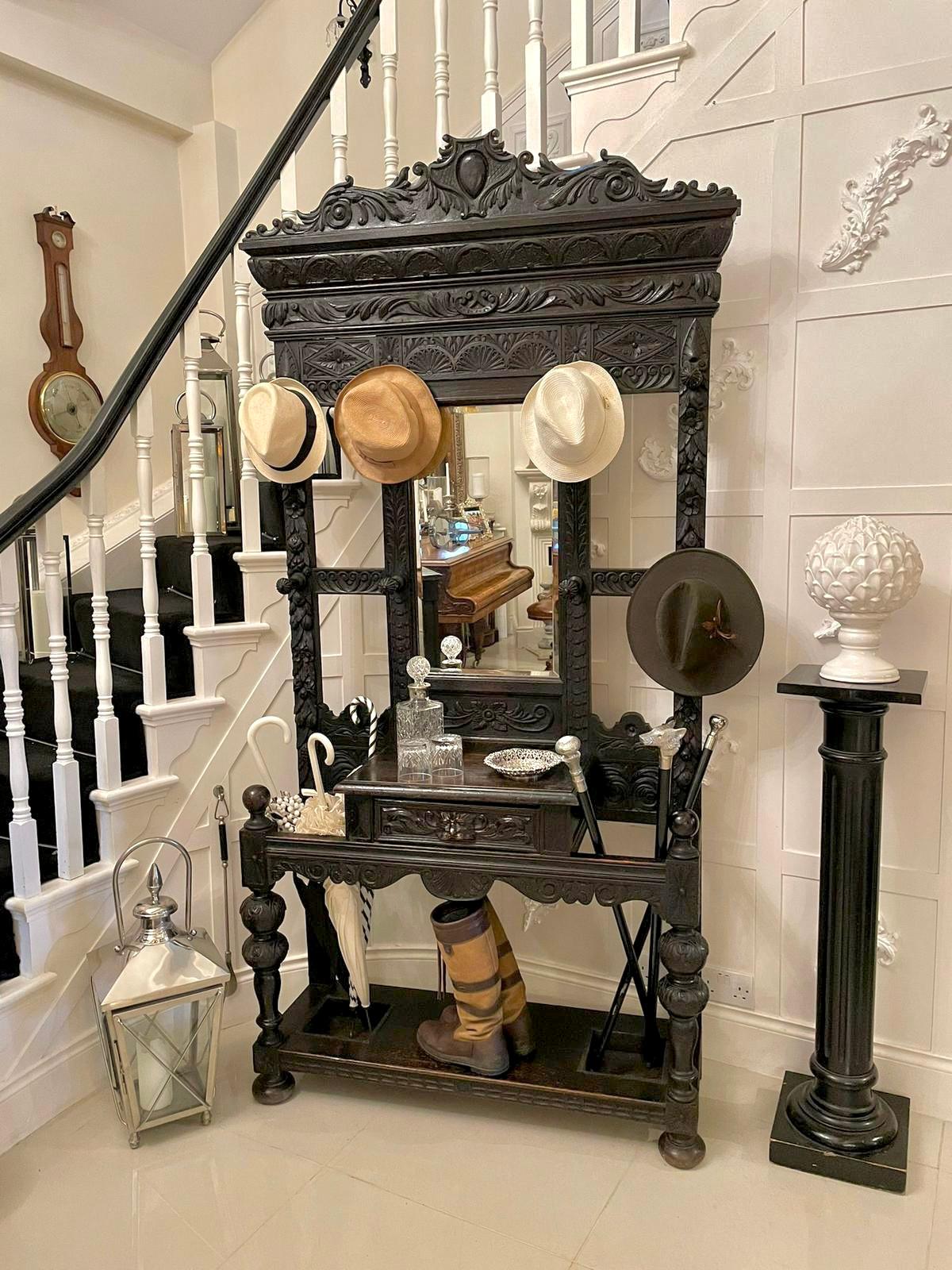 Large antique Victorian quality carved oak hall stand having a quality carved oak shaped back with carved lions heads, sunflowers ,leaves, scrolls and foliage. It boasts a bevelled edge mirror to the centre, original turned oak hat pegs, centre