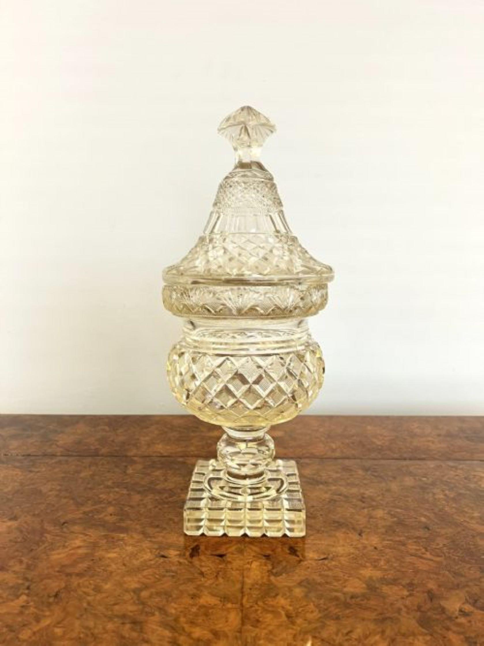 Large antique Victorian quality cut glass lidded vase having a quality cut glass detailed lidded vase with a shaped cut glass lid above a circular cut glass vase supported but a square base 