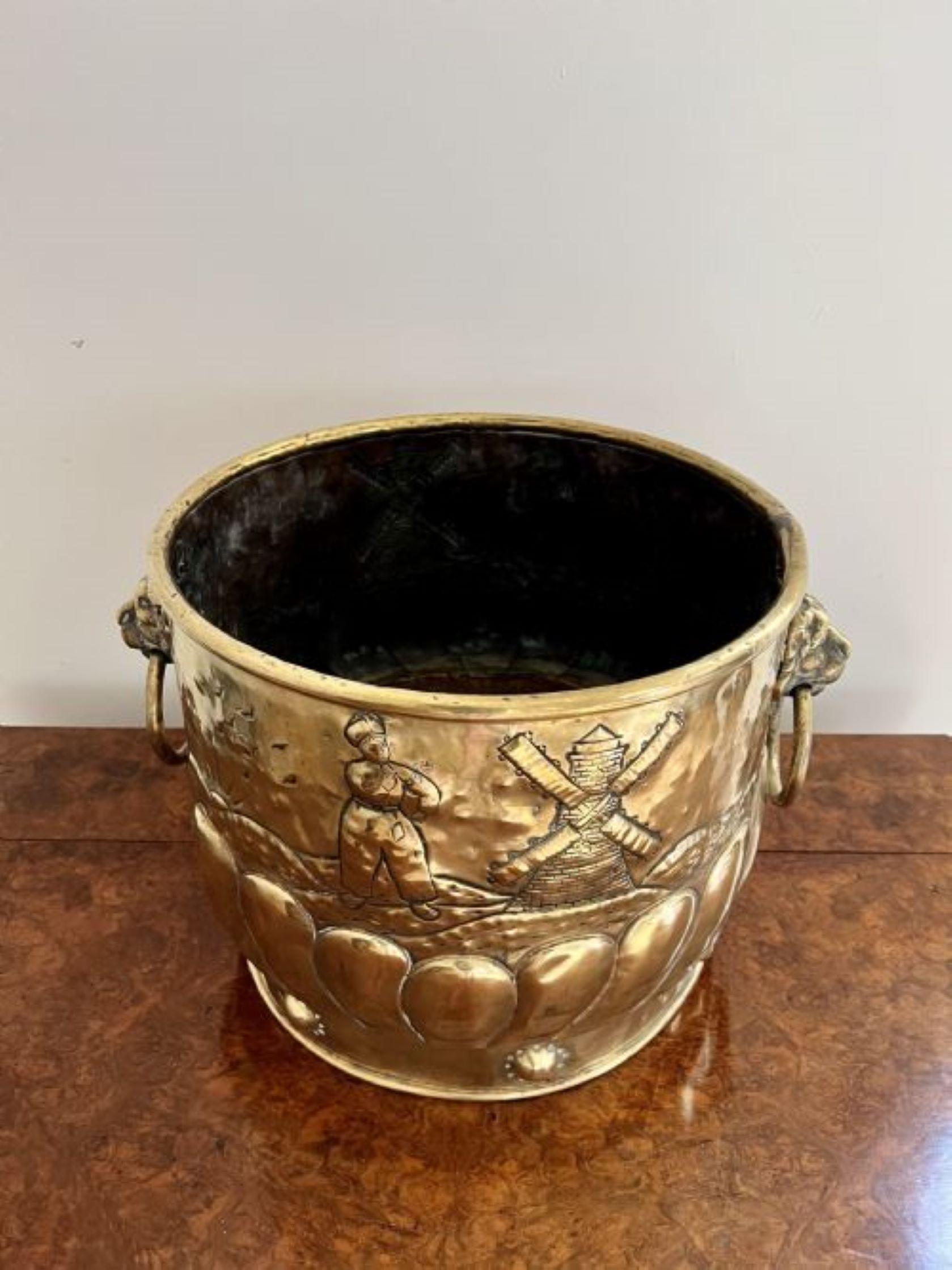 Large Antique Victorian Dutch Brass Jardiniere having a quality antique Victorian Dutch brass jardiniere, Having lions heads ring handles to the sides, decorated with traditional scenes throughout with a shaped body raised on a circular base.