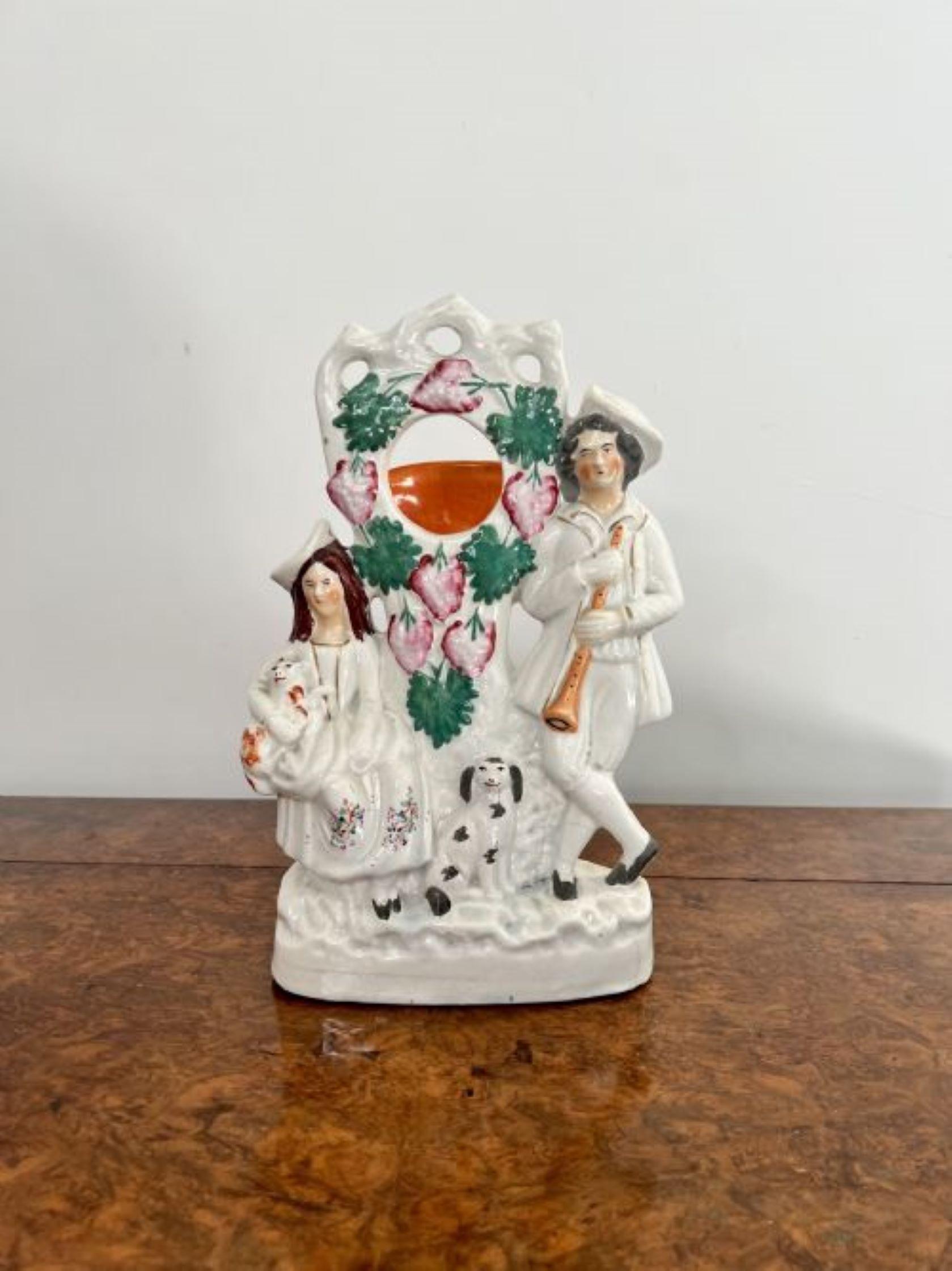 Großer antiker Staffordshire-Uhrenhalter von viktorianischer Qualität mit zwei Figuren eines Mannes, der ein Instrument hält, einer Dame, die ein Schaf hält, und einem Hund in der Mitte, verziert mit handgemalten rosafarbenen Blumen und grünen