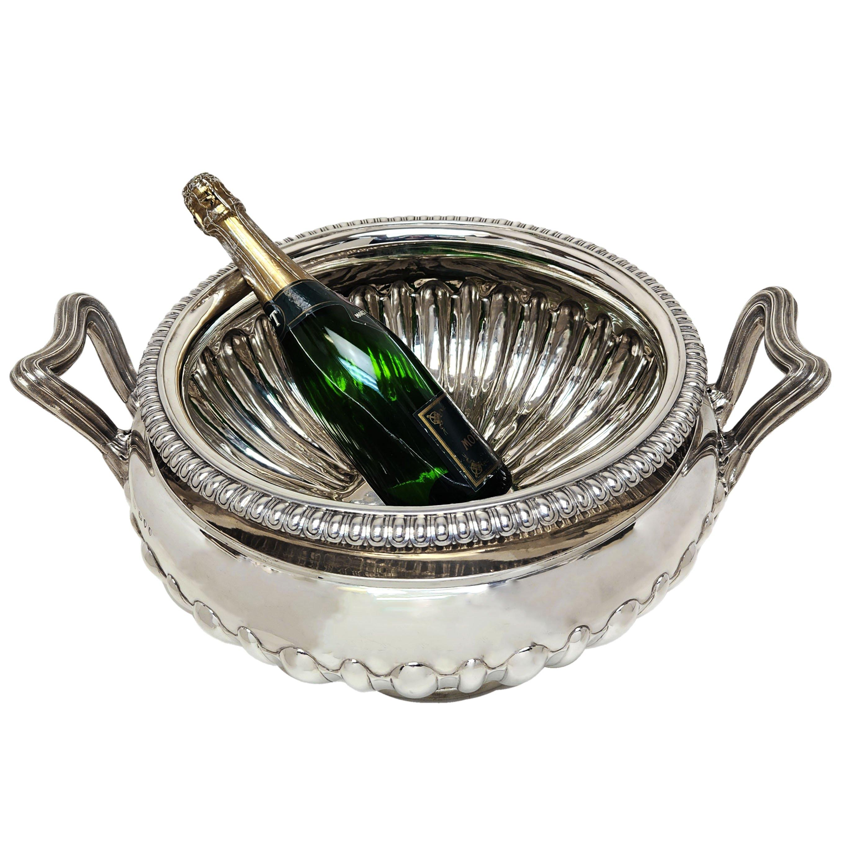 A monumental Antique Victorian Silver Two Handled Bowl with a classic fluted design on the body and a patterned rim. The Bowl has two substantial reeded handles. This bowl is of a very large size and is suitable as a champagne / wine cooler that can