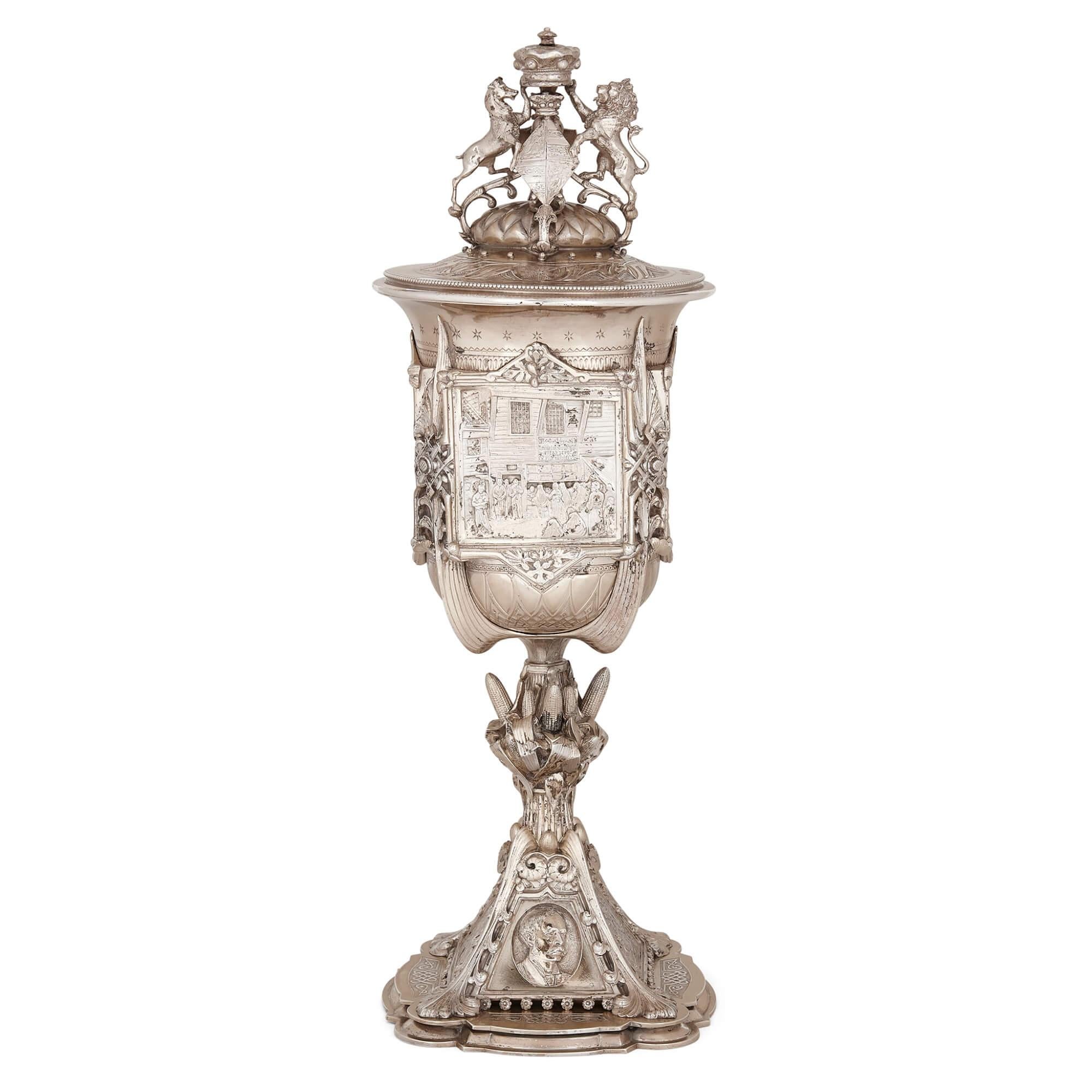 Large antique Victorian silver loving cup and cover 
English, 1881
Height 40cm, width 13.5cm, depth 13.5cm

This large antique cup and cover is a traditional ‘loving cup’, an ornamental drinking vessel used to mark significant events. Typically made