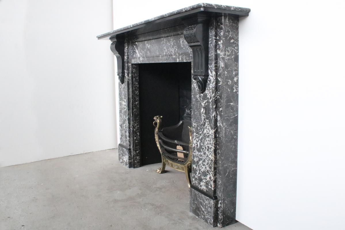 Large antique Victorian St Anne marble fireplace surround with well carved Belgian black marble corbels and detailing, circa 1880.

Pictured with a Victorian cast iron and bronze fire grate, sold separately.