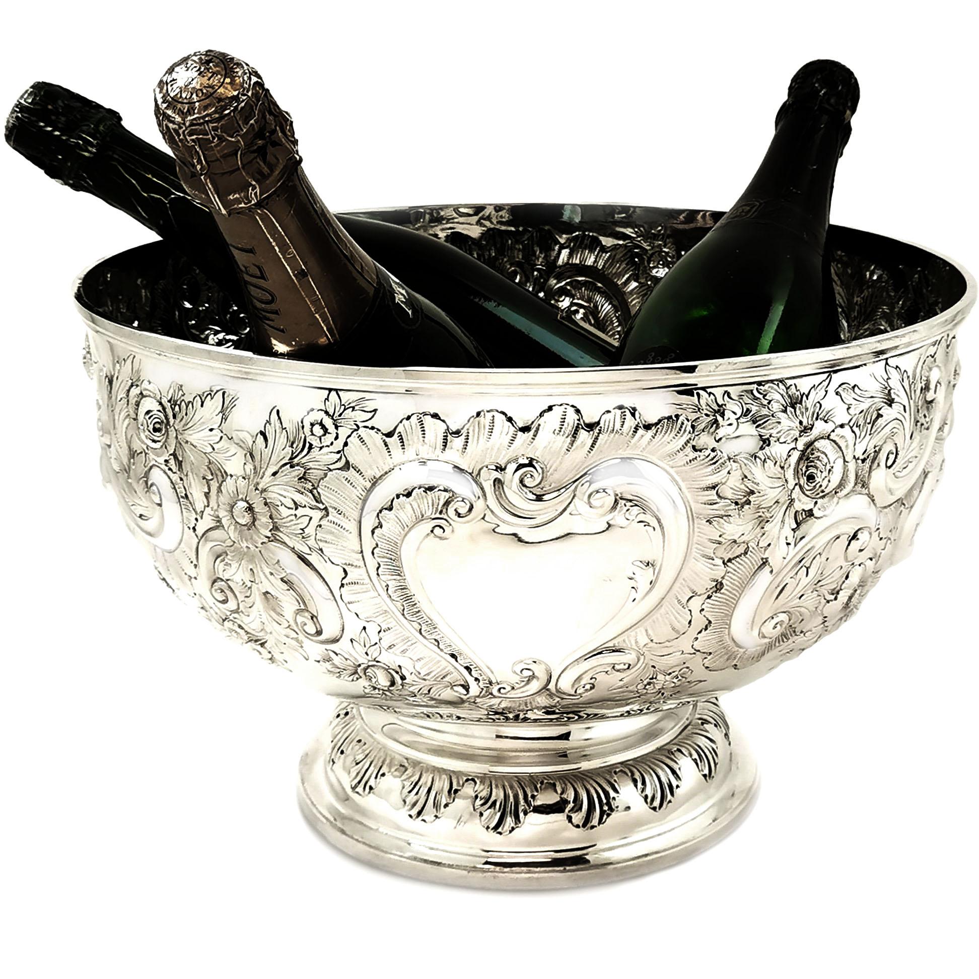 A magnificent Antique Victorian solid Silver Bowl decorated with an ornate chased floral, scroll and foliate design around a pair of blank cartouches. This Bowl is of notably large size and is an impressive display piece and is large enough as a